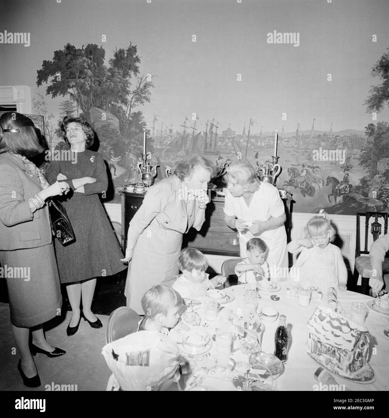 Fête d'anniversaire pour Caroline Kennedy et John F. Kennedy, Jr. John F. Kennedy, Jr. (Assis au centre), mange à une table dans la salle à manger du Presidentu2019s (résidence) de la Maison Blanche, Washington, D.C., lors d'une fête d'anniversaire conjointe pour lui et sa sœur, Caroline Kennedy. Nanny aux enfants Kennedy, Maud Shaw, se tient derrière John, Jr.; Eunice Kennedy Shriver parle avec une femme non identifiée à gauche. Banque D'Images Fête d'anniversaire pour Caroline Kennedy et John F. Kennedy, Jr. John F. Kennedy, Jr. (Assis au centre), mange à une table dans la salle à manger du Presidentu2019s (résidence) de la Maison Blanche, Washington, D.C., lors d'une fête d'anniversaire conjointe pour lui et sa sœur, Caroline Kennedy. Nanny aux enfants Kennedy, Maud Shaw, se tient derrière John, Jr.; Eunice Kennedy Shriver parle avec une femme non identifiée à gauche. Banque D'Images