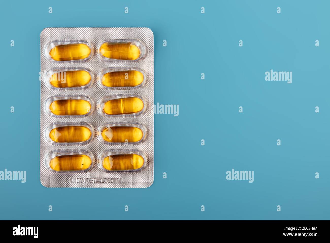Assiette en emballage en capsules de vitamine d, huile de poisson sur fond bleu. Espace pour le texte Banque D'Images