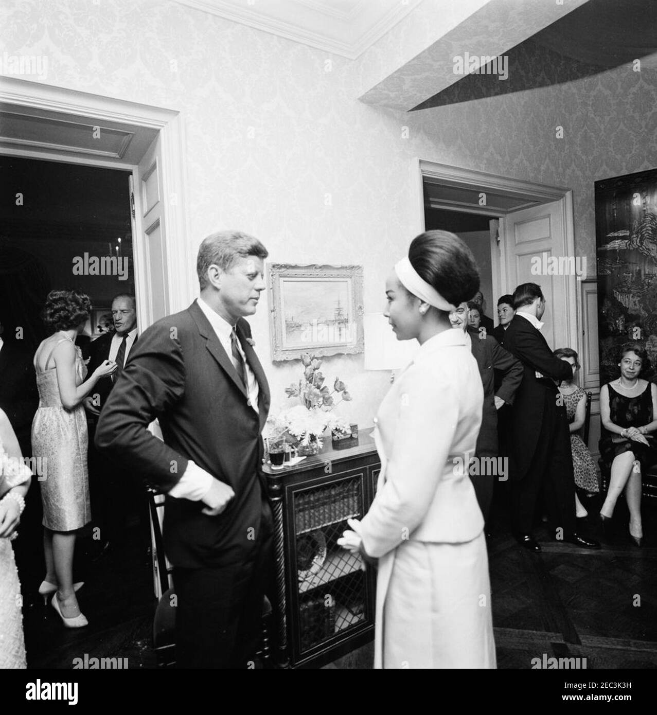 Voyage à New York : réception, résidence Arthur Krim. Le président John F. Kennedy visite avec l'acteur et chanteur, Diahann Carroll, lors d'une réception en soirée à la résidence d'Arthur B. Krim et du Dr Mathilde Krim à New York. Eunice Kennedy Shriver se trouve à l'extrême gauche en arrière-plan. Banque D'Images Voyage à New York : réception, résidence Arthur Krim. Le président John F. Kennedy visite avec l'acteur et chanteur, Diahann Carroll, lors d'une réception en soirée à la résidence d'Arthur B. Krim et du Dr Mathilde Krim à New York. Eunice Kennedy Shriver se trouve à l'extrême gauche en arrière-plan. Banque D'Images