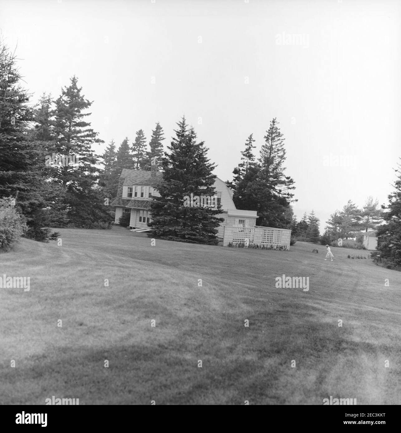 Le personnel de la White House Communications Agency (WHCA) voyage à l'avance dans le Maine. Vue de la résidence privée de l'ancien champion de boxe poids lourd, Gene Tunney, alors que le personnel de l'Agence de communication de la Maison Blanche (WHCA) se prépare pour le voyage du président John F. Kennedyu0027s dans le Maine. Une femme non identifiée marche à droite en arrière-plan. Johns Island, Johns Bay, Maine. Banque D'Images Le personnel de la White House Communications Agency (WHCA) voyage à l'avance dans le Maine. Vue de la résidence privée de l'ancien champion de boxe poids lourd, Gene Tunney, alors que le personnel de l'Agence de communication de la Maison Blanche (WHCA) se prépare pour le voyage du président John F. Kennedyu0027s dans le Maine. Une femme non identifiée marche à droite en arrière-plan. Johns Island, Johns Bay, Maine. Banque D'Images