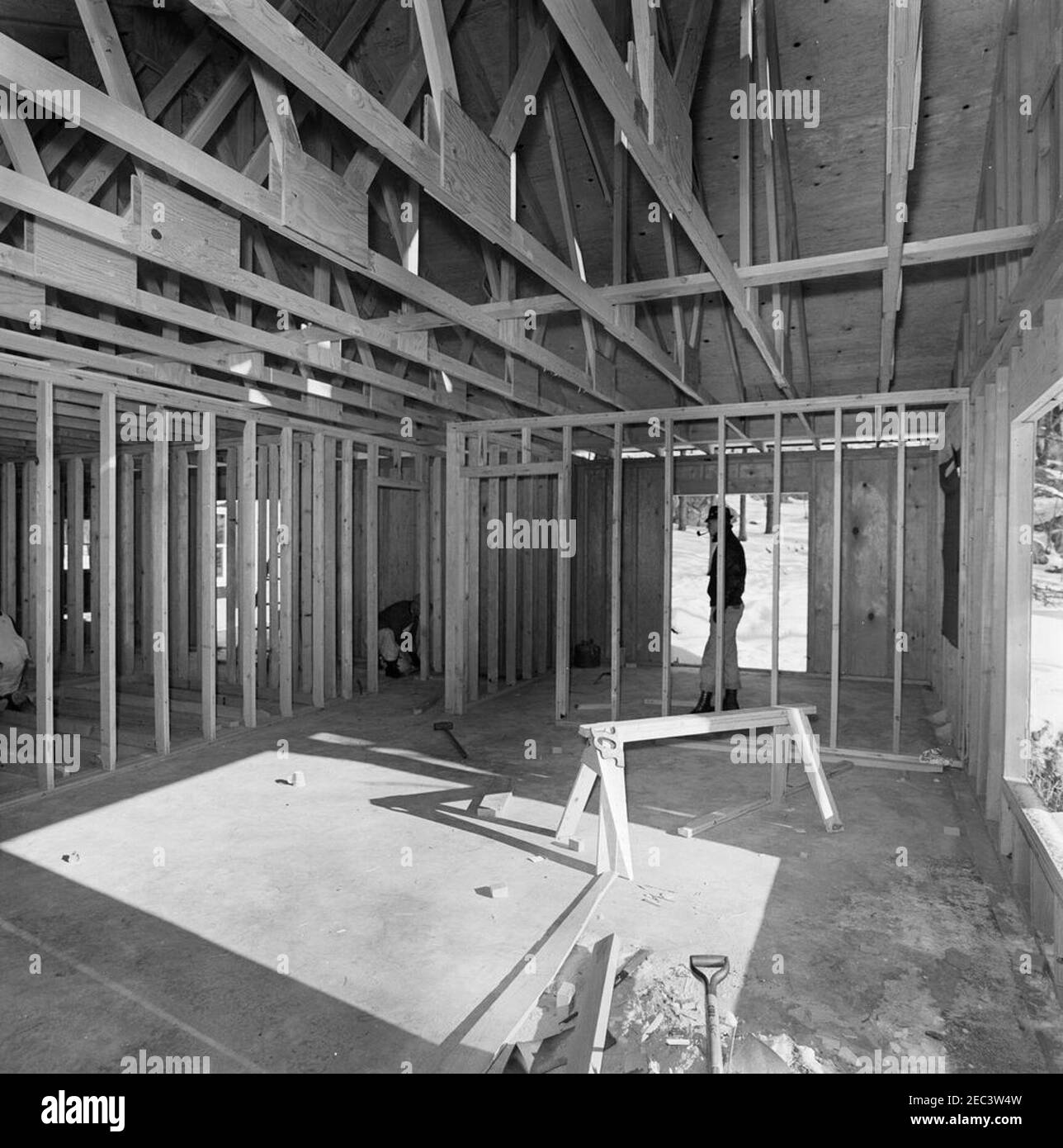 Atoka, Virginie avancement de la construction (y compris des vues aériennes). Un homme non identifié (à l'arrière, pipe à fumer) observe que deux hommes non identifiés (un partiellement caché à l'extrême gauche du cadre) travaillent à la construction intérieure de Wexford, résidence du Président John F. Kennedyu0027s à Atoka, en Virginie. Banque D'Images Atoka, Virginie avancement de la construction (y compris des vues aériennes). Un homme non identifié (à l'arrière, pipe à fumer) observe que deux hommes non identifiés (un partiellement caché à l'extrême gauche du cadre) travaillent à la construction intérieure de Wexford, résidence du Président John F. Kennedyu0027s à Atoka, en Virginie. Banque D'Images