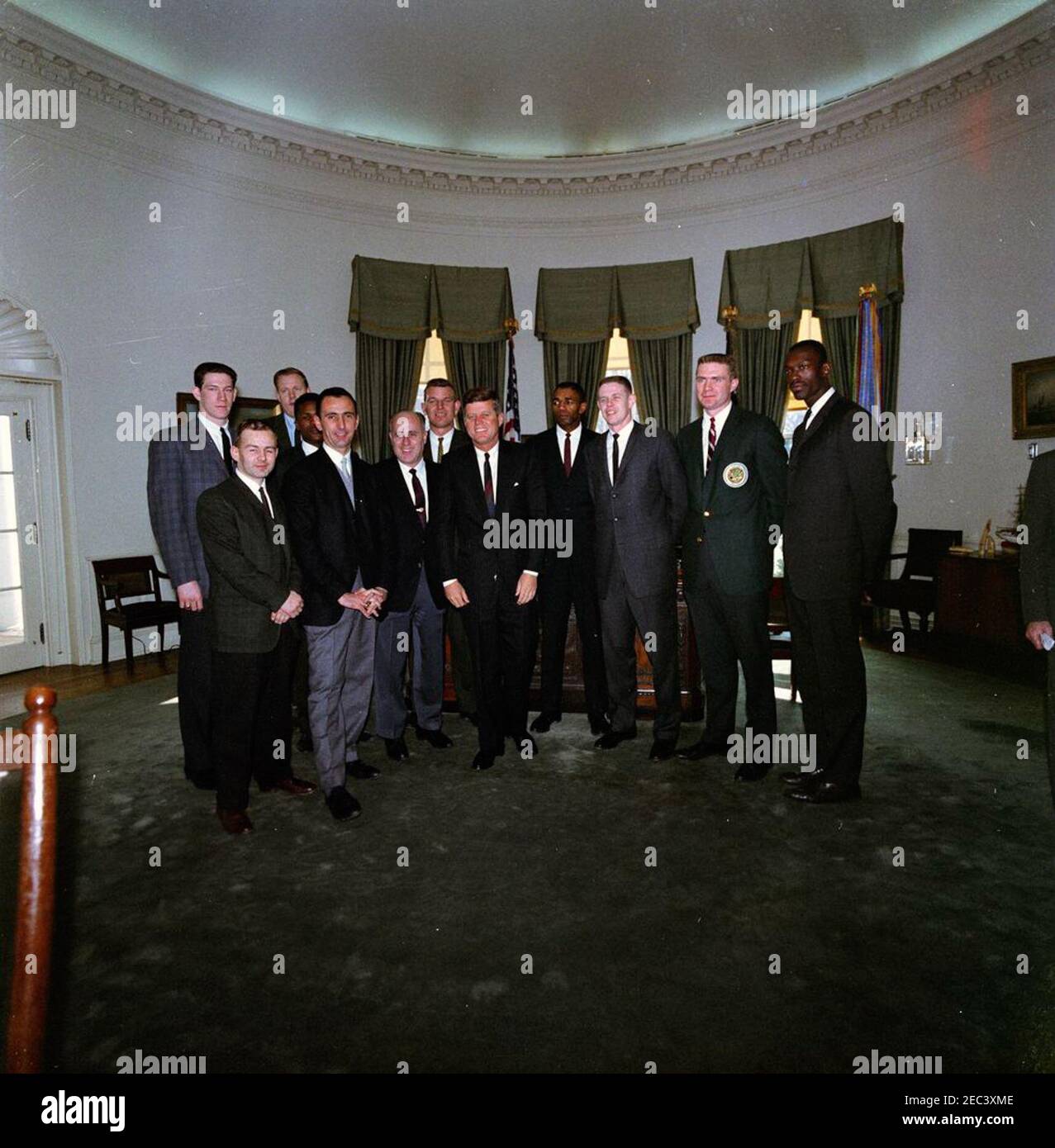 Visite de l'équipe de basket-ball Boston Celtics, 13:00. Les membres de l'équipe de Boston Celtics de la National Basketball Association (NBA) visitent le Président John F. Kennedy dans le Bureau ovale lors d'une visite de la Maison Blanche. (G-D) Edward G. u0022Buddyu0022 Leroux, Jr.; John Havlicek (à l'arrière); Bob Cousy; K. C. Jones (partiellement caché derrière M. Cousy); Clyde Lovellette (à l'arrière); Coach Red Auerbach; Jim Lostoff (à l'arrière); Président Kennedy; Sam Jones; Frank Ramsey; Tom Heinsohn; Tom Sanders et Tom. Washington, D.C. [les rayures et la décoloration sont originales au négatif.] Banque D'Images