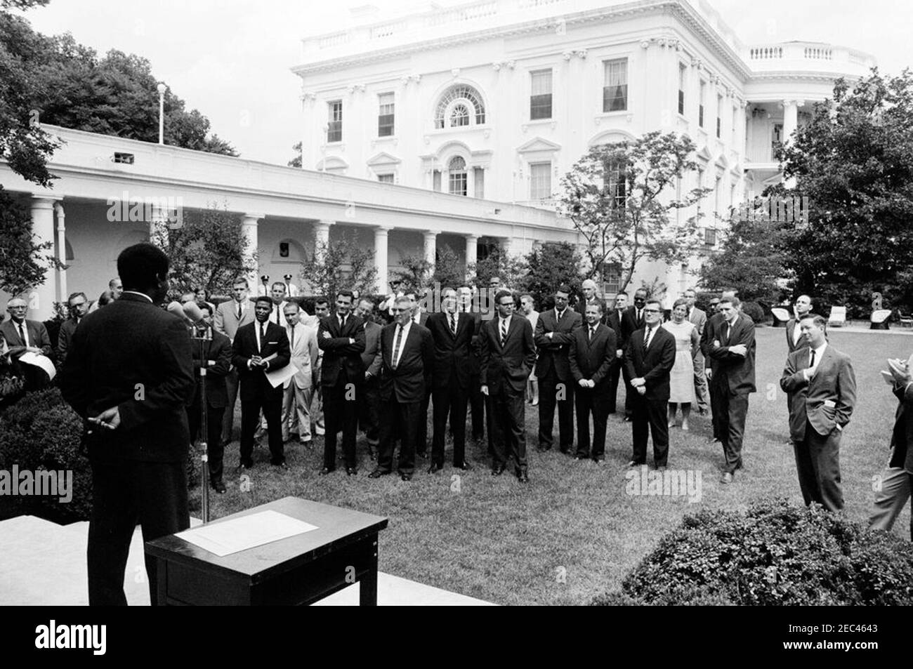 Sargent Shriver, Directeur du corps de la paix, avec des volontaires se rendant à Tanganyika. Le ministre des Affaires extérieures et de la Défense de Tanganyika, Oscar S. Kambona, s'adresse aux volontaires du corps de la paix qui doivent servir à Tanganyika. Rose Garden, Maison Blanche, Washington D.C. Banque D'Images