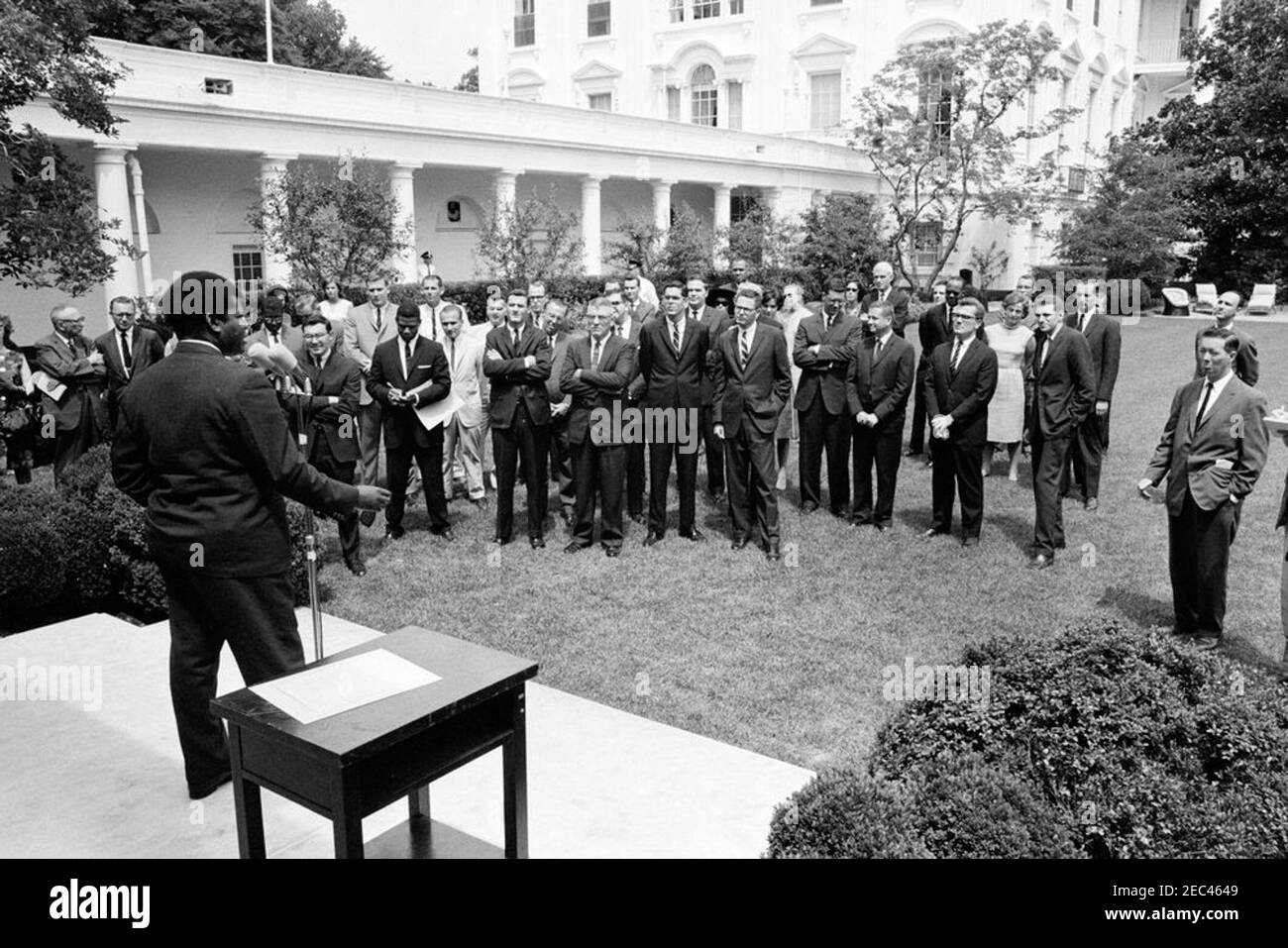 Sargent Shriver, Directeur du corps de la paix, avec des volontaires se rendant à Tanganyika. Le ministre des Affaires extérieures et de la Défense de Tanganyika, Oscar S. Kambona, s'adresse aux volontaires du corps de la paix qui doivent servir à Tanganyika. Rose Garden, Maison Blanche, Washington D.C. Banque D'Images