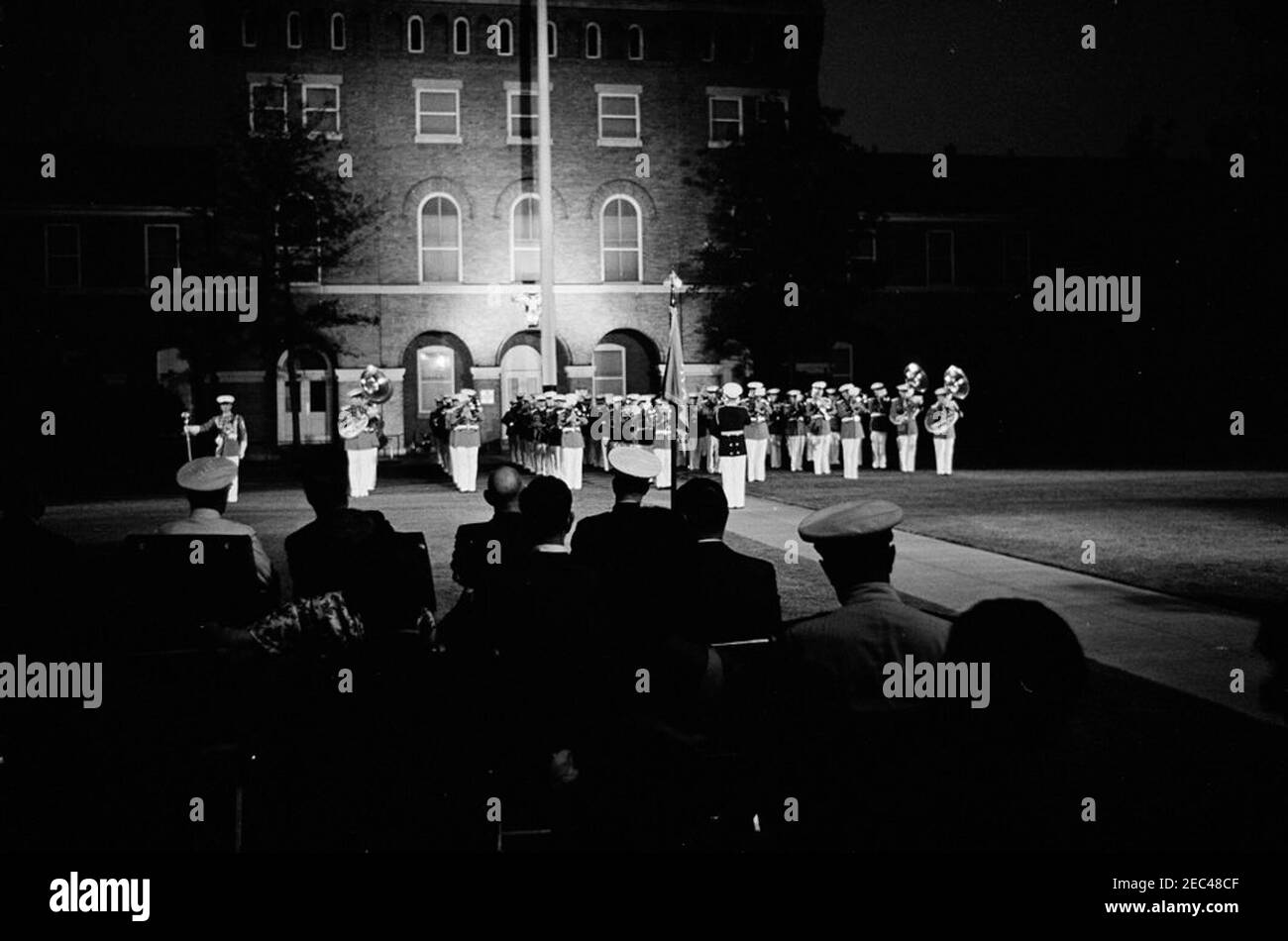 Le Président Kennedy voit la Marine Corpsu0027 Evening Parade, à la Marine Barracks Washington, D.C. (8th u0026 I Streets, se), 9:00. Le Président John F. Kennedy assiste à une parade du soir à la caserne des Marines (u201c8th u0026 Iu201d) à Washington, D.C., assise en première ligne avec dos à la caméra (L-R) : Commandant du corps des Marines des États-Unis, général David M. Shoup; Président Kennedy; sénateur Richard B. Russell (Géorgie); non identifié. Les membres du corps de batterie et de bugle des États-Unis se tiennent en formation à l'arrière-plan. Banque D'Images