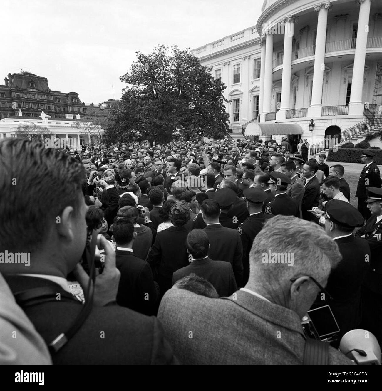 Réception pour étudiants étrangers, 3:55. Le Président John F. Kennedy (au centre, le chef tourne) accueille les participants à une réception pour les étudiants étrangers sur la pelouse sud de la Maison Blanche, Washington, D.C. les invités incluent des étudiants des institutions suivantes de la région de Washington, D.C. : Université américaine, Université catholique d'Amérique, Collège Gallaudet, Université George Washington, Université Georgetown, Université Howard, École d'études internationales avancées de l'Université Johns Hopkins, Trinity College (Washington, D.C.), Université du Maryland et Collège Dunbarton de Sainte Croix. Aussi Banque D'Images