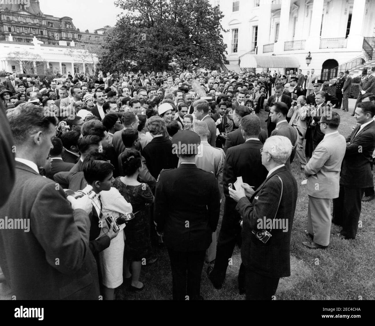 Réception pour étudiants étrangers, 3:55. Le Président John F. Kennedy (au centre) accueille les invités lors d'une réception pour les étudiants étrangers sur la pelouse sud de la Maison Blanche, Washington, D.C. les participants incluent des étudiants des institutions suivantes de la région de Washington, D.C. : Université américaine, Université catholique d'Amérique, Collège Gallaudet, Université George Washington, Université Georgetown, Université Howard, École d'études internationales avancées de l'Université Johns Hopkins, Trinity College (Washington, D.C.), Université du Maryland et Collège Dunbarton de Sainte Croix. Également illustré : Banque D'Images