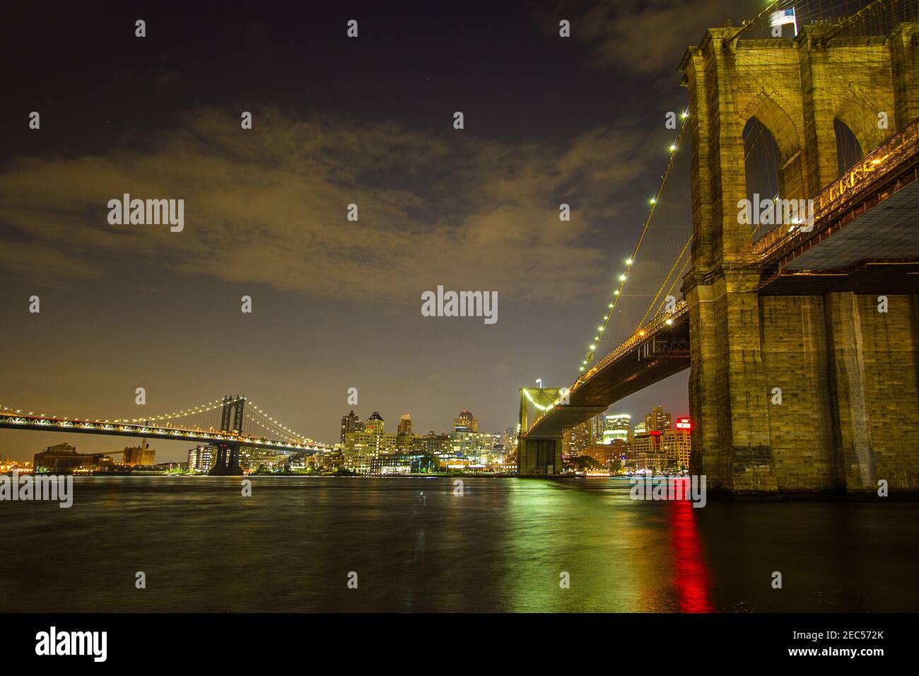 Vue sur le pont de Brooklyn depuis Manhattan la nuit Avec le reflet de la lumière de la ville sur East River Et Manhattan Bridge en arrière-plan Banque D'Images