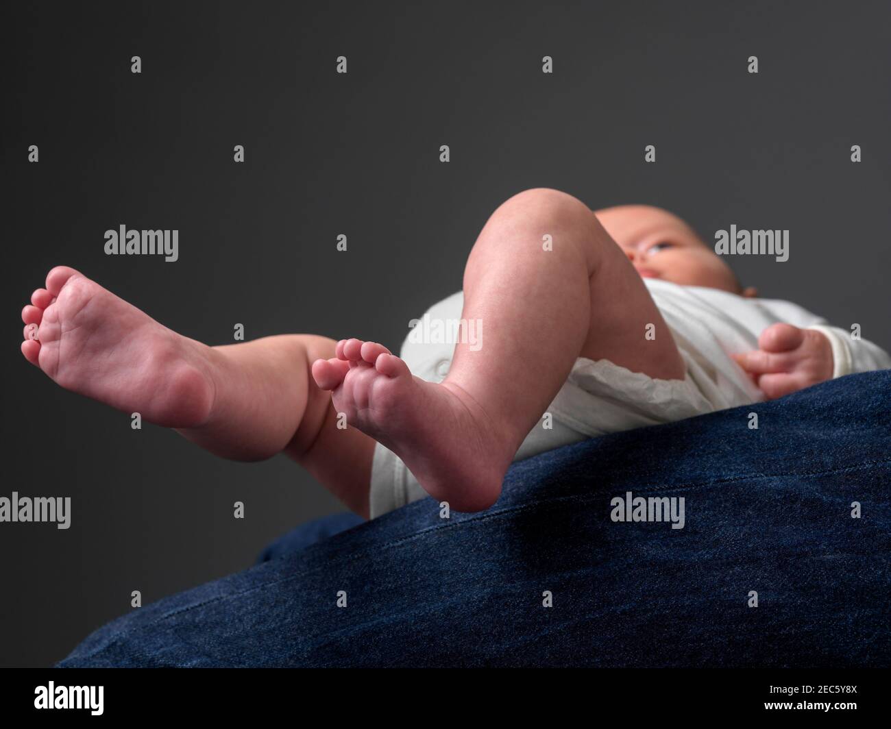 bébé sur les semelles de genoux du père proéminentes Banque D'Images