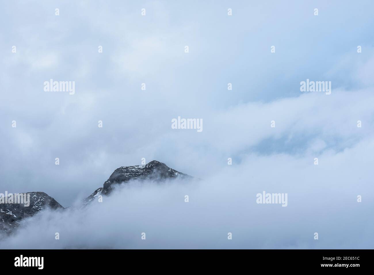 Superbe paysage d'hiver, vue de Side Pike vers Langdale pikes avec des nuages bas niveau sur les sommets de montagne et brume d'humeur changeante Banque D'Images