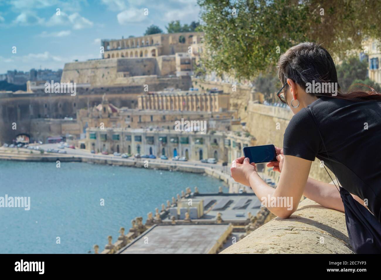 Voyageur femme regardant la Valette, la capitale de Malte, paysage urbain et prenant des photos avec le téléphone mobile de la Valette vue Banque D'Images