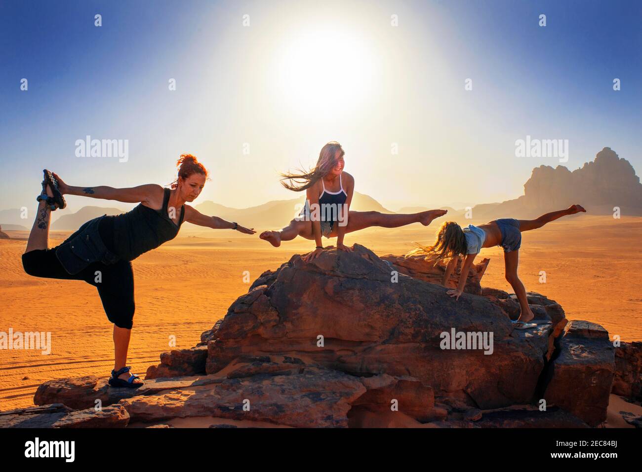 Touristes faisant des exercices de gymnastique dans le désert de Wadi Rum en Jordanie Banque D'Images