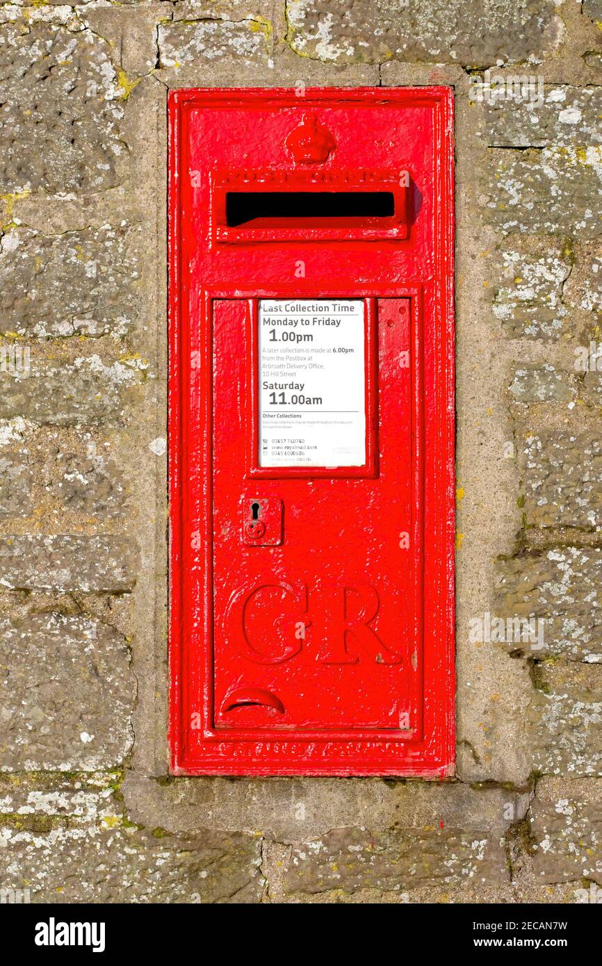 Une boîte aux lettres britannique rouge ou une boîte aux lettres fixée dans un mur à la périphérie d'Arbroath, en Écosse. Il porte le chiffre de George V (1910-1936). Banque D'Images