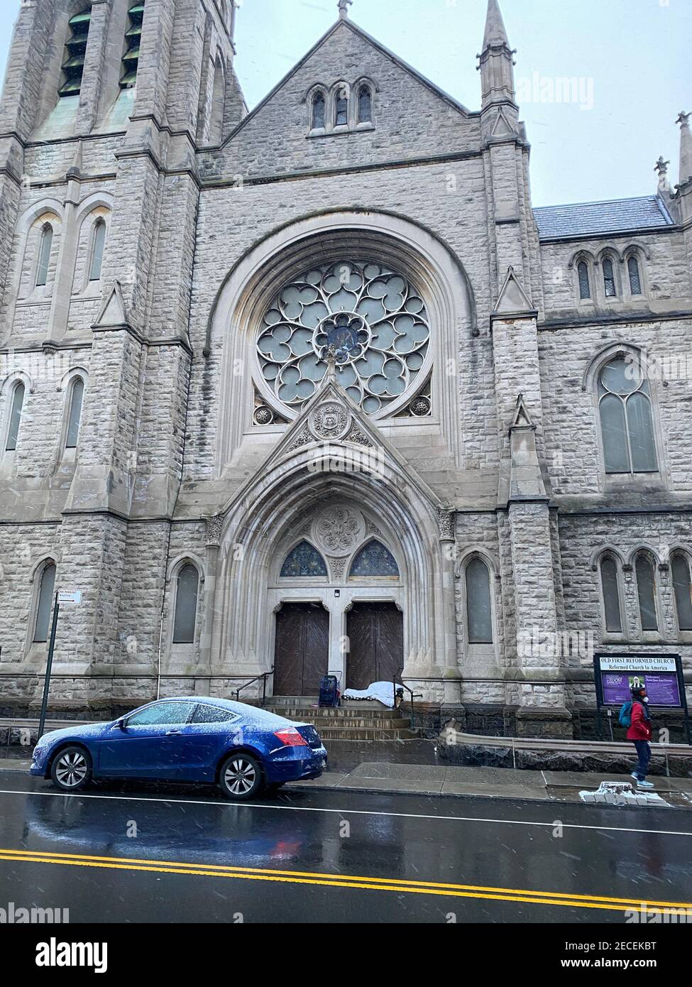 Matin pluvieux avec un homme dormant à la porte d'une église sur la 7th Avenue dans le quartier Park Slope de Brooklyn, New York. Banque D'Images