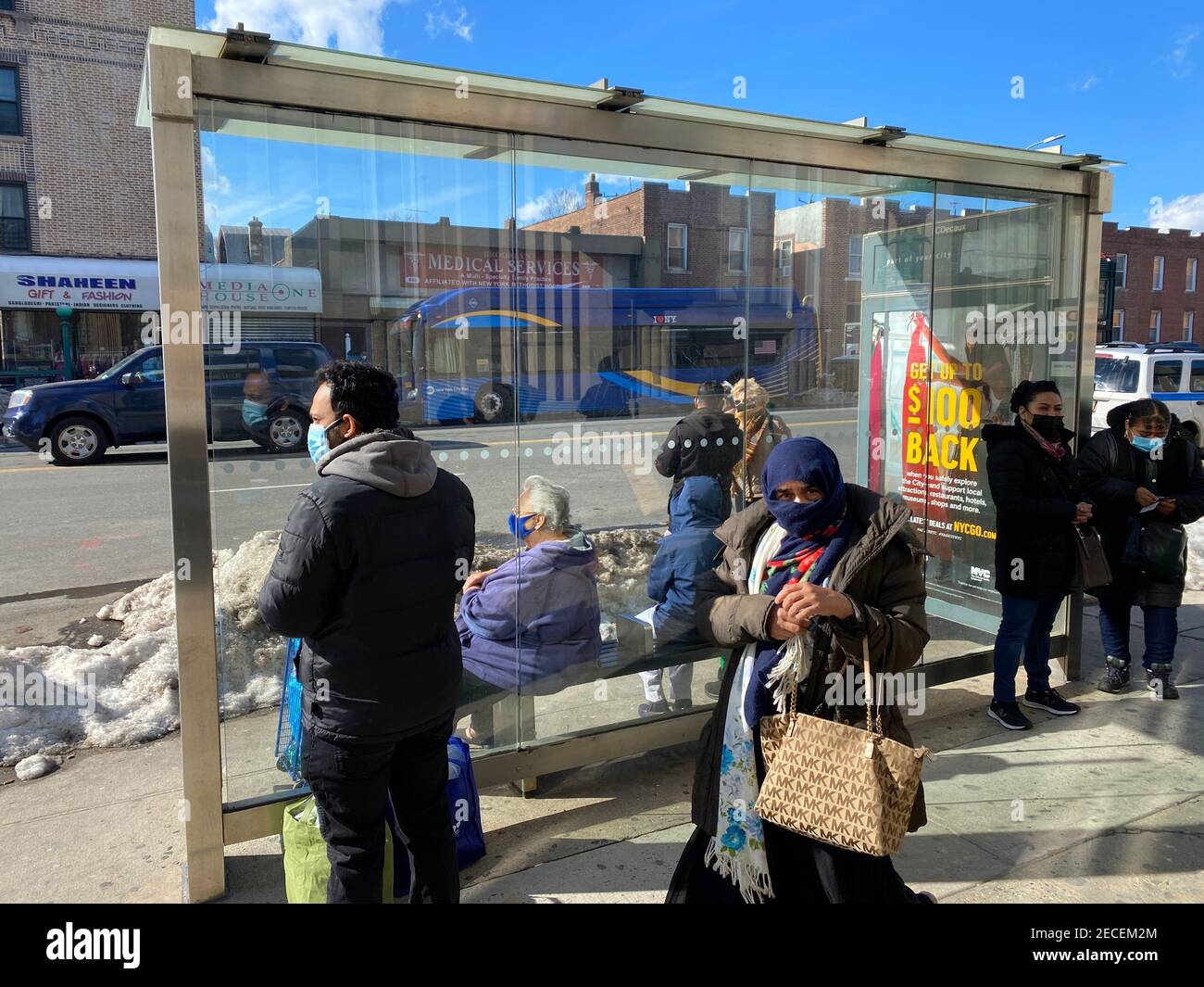 Les gens attendent à un arrêt de bus dans le quartier multiculturel de Kensington à Brooklyn, New York. Banque D'Images