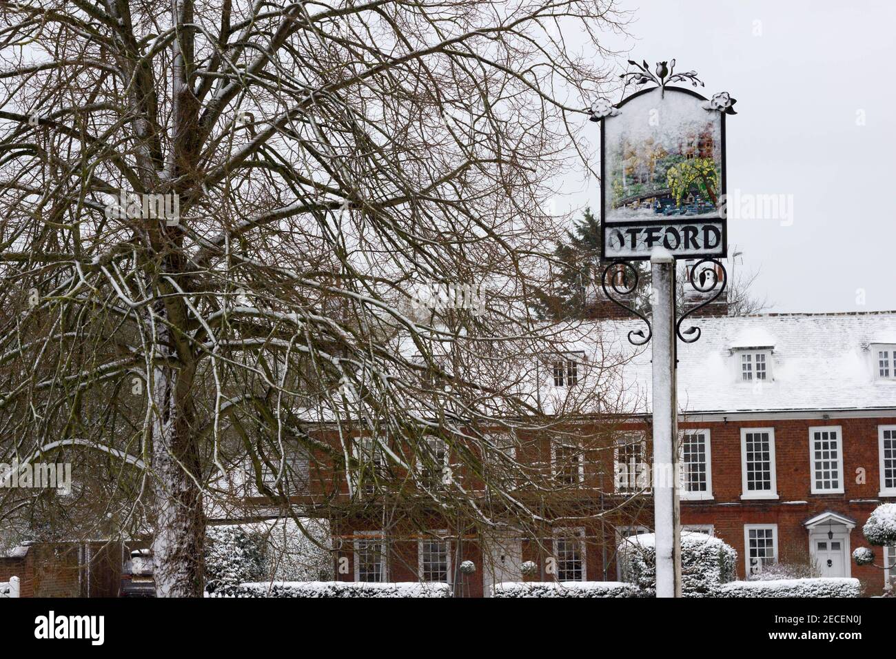 Bannière d'Otford sur la poste à côté d'un arbre couvert de neige, entouré par une maison en brique rouge en terrasse dans le Kent Banque D'Images