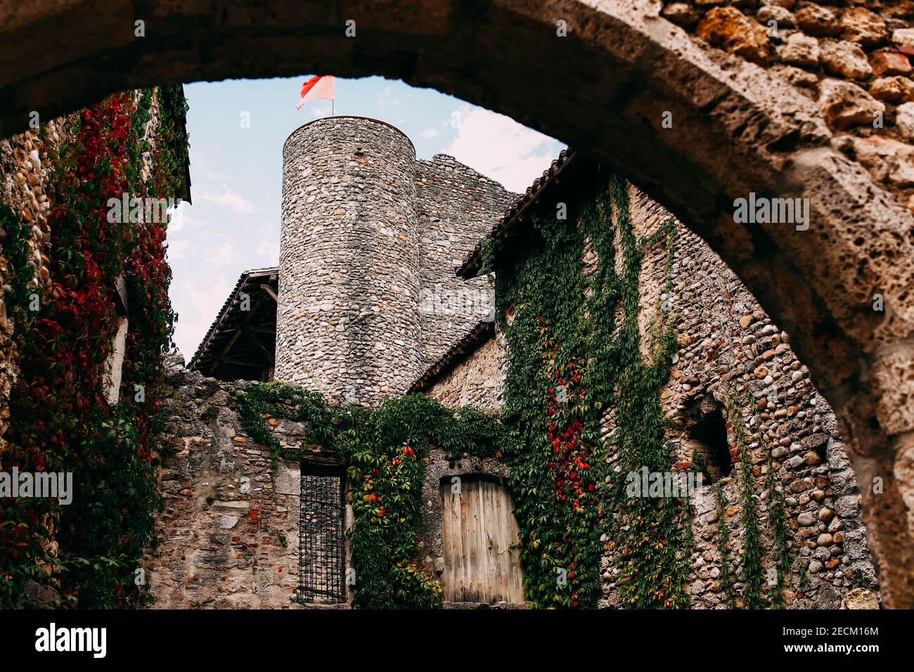 Façade de vieux bâtiments en pierre à Perouges, fenêtres rouges, fleurs, lierre, France. Photo de haute qualité Banque D'Images