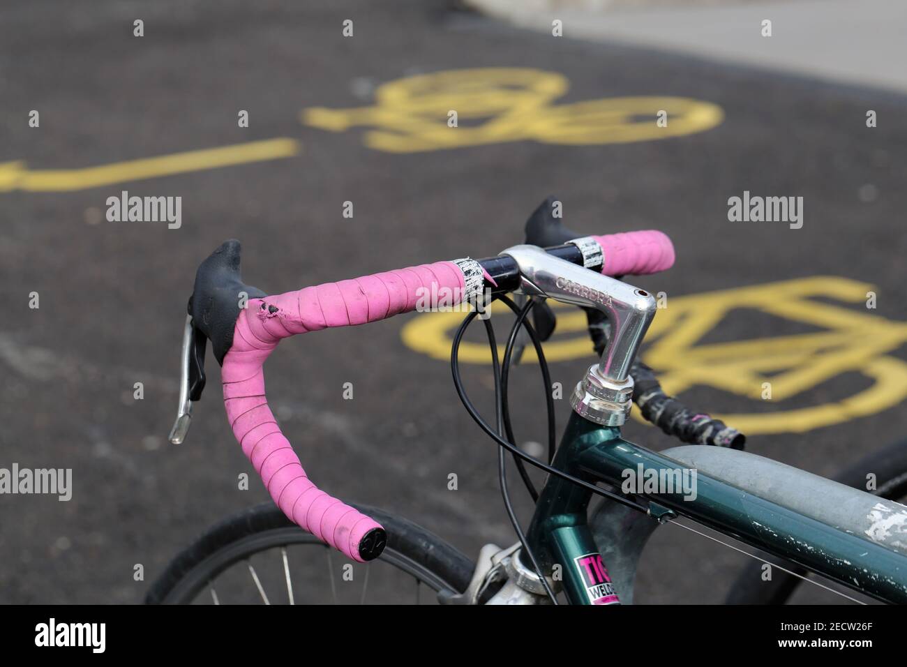 Gros plan des détails d'une bicyclette garée située à Zurich, Suisse, mars 2020. Image couleur avec tons gris, argent, rose, vert et jaune. Banque D'Images