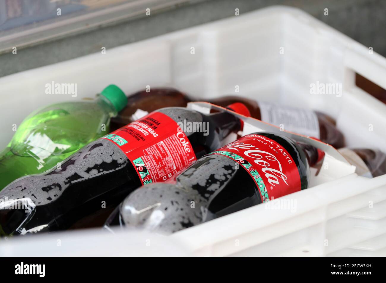 Plusieurs grandes bouteilles de boisson gazeuse Coca-Cola en plastique et d'autres bouteilles de limonade dans une grande boîte de contenant blanche. Boissons malsaines mais délicieuses. Gros plan. Banque D'Images