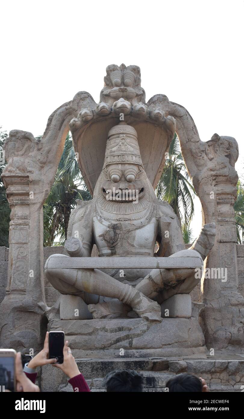 touriste prenant des photos de pierre hypnotisant sculpté statut du dieu hindou Vishnu dans son avatar Narsimha, qui est un demi-lion et un demi-homme à Hampi Banque D'Images