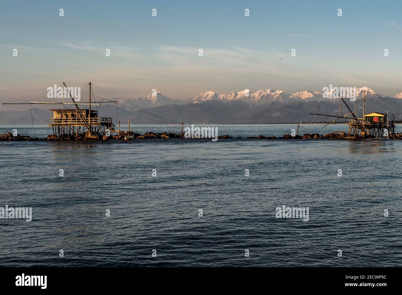 Deux cabanes de pêche au trébouchet contre les Alpes couvertes de neige, Marina di Pisa, Toscane, Italie Banque D'Images