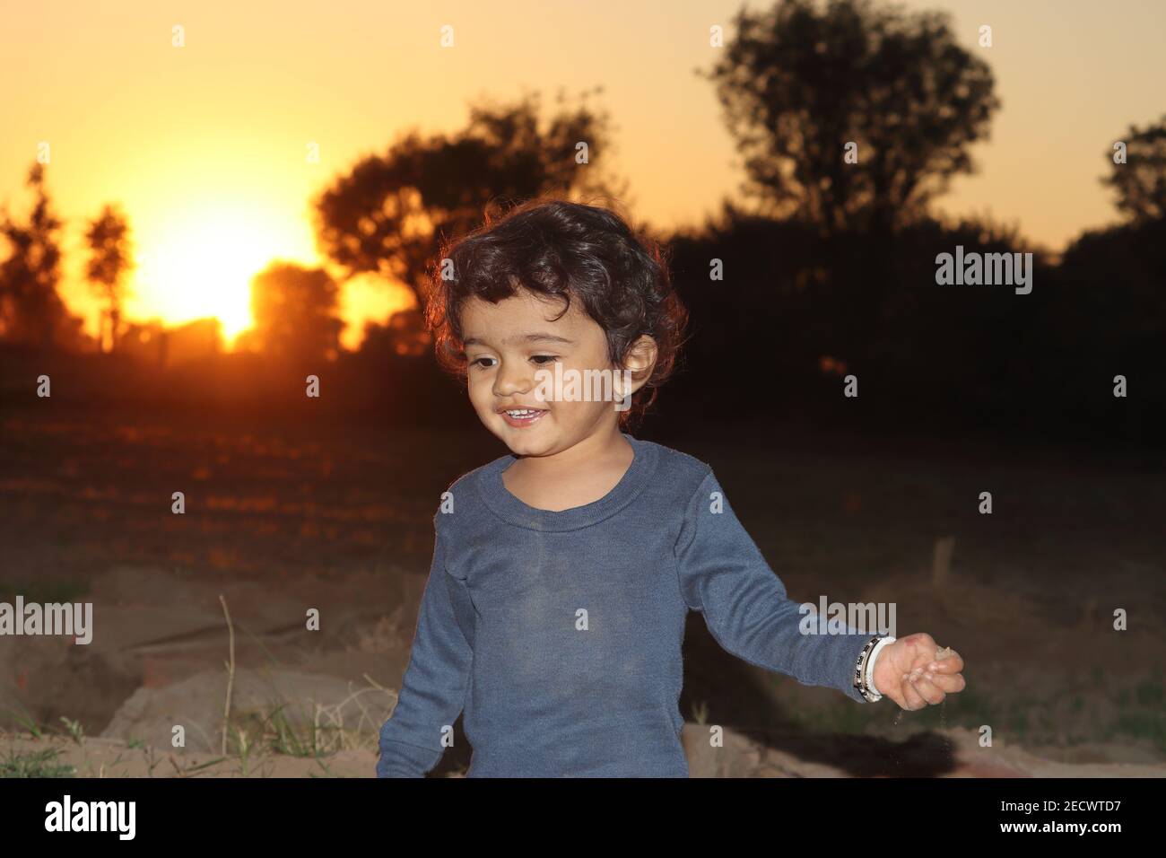 Une photo portrait en gros plan de beau petit enfant hindou jouant dans le jardin au coucher du soleil, enfant indien Banque D'Images
