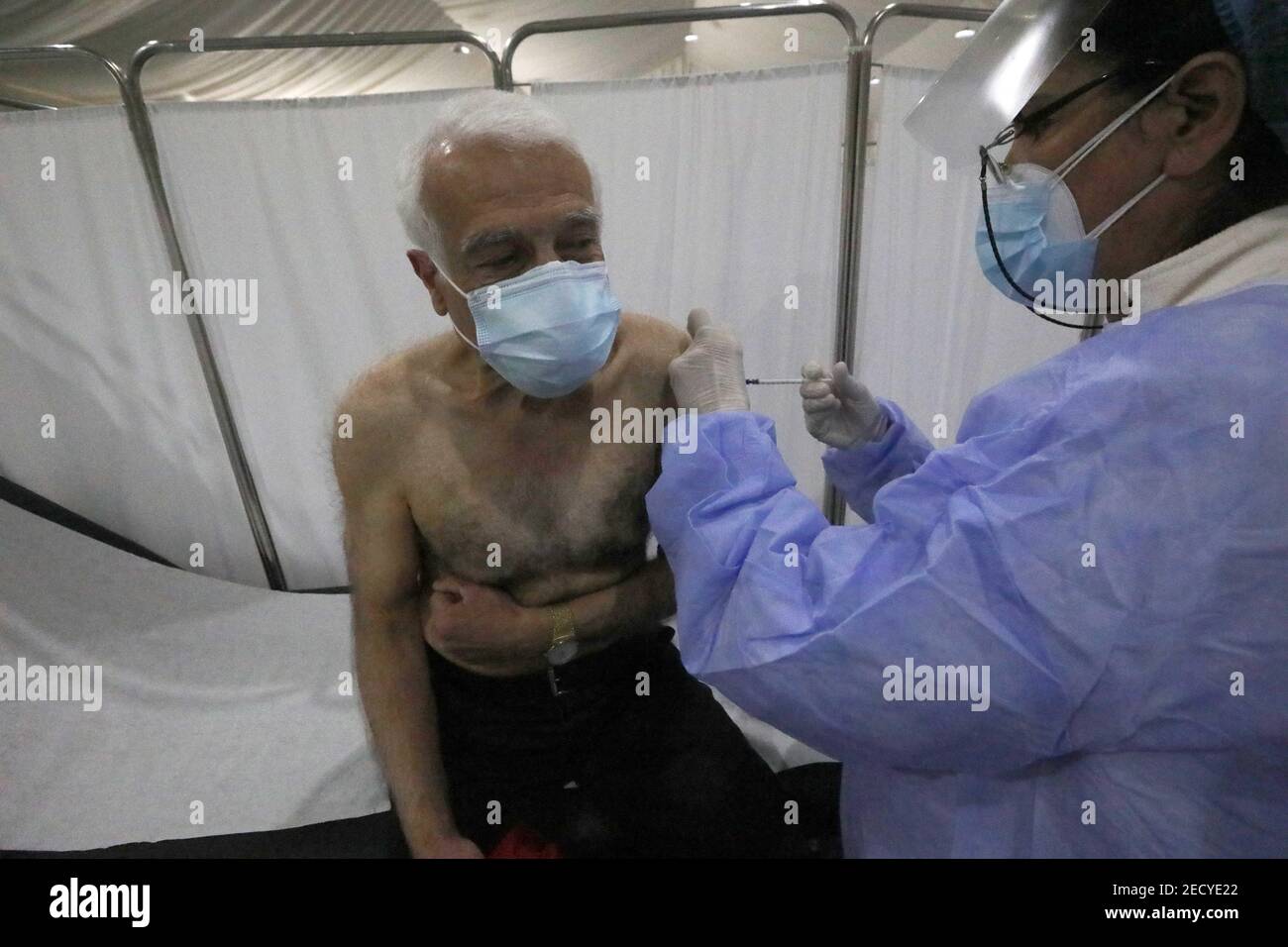 Beyrouth, Liban. 14 février 2021. Un membre du personnel âgé de l'hôpital Saint George reçoit une dose de vaccin contre le COVID-19 à Beyrouth, au Liban, le 14 février 2021. Le Liban a lancé dimanche sa campagne de vaccination en commençant par les employés du secteur de la santé après avoir reçu, un jour plus tôt, 28,500 vaccins de Pfizer-BioNTech, a rapporté la chaîne de télévision locale LBCI. Credit: Bilal Jawich/Xinhua/Alay Live News Banque D'Images
