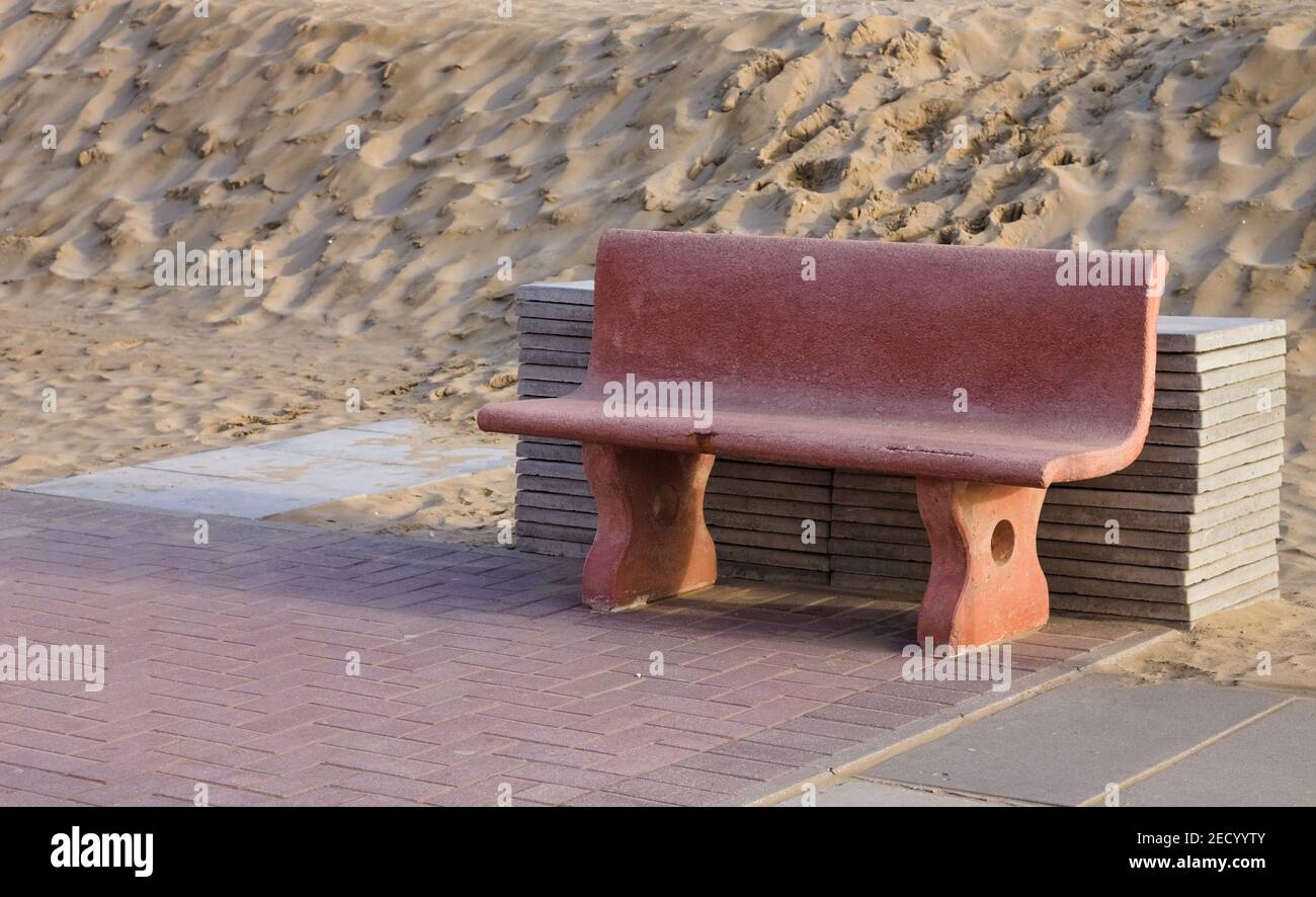 Banc rose avec tuiles empilées devant une dune de sable (Pesaro, Italie, Europe) Banque D'Images