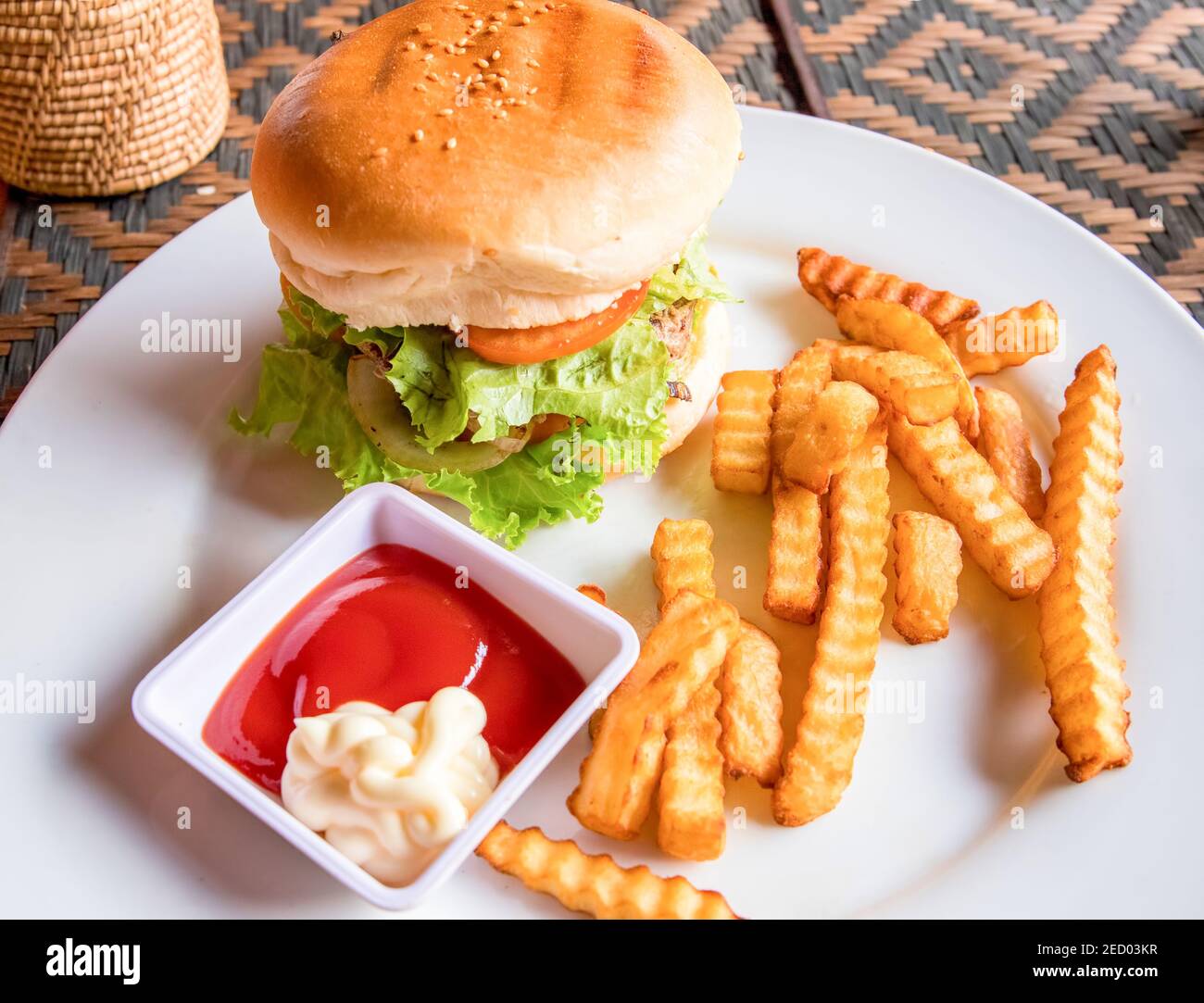 Hamburger de bœuf avec frites, ketchup et mayonnaise sur plaque blanche. Petit déjeuner riche en éléments nutritifs. Hamburger américain. Encas simple servi pour plus de bien Banque D'Images