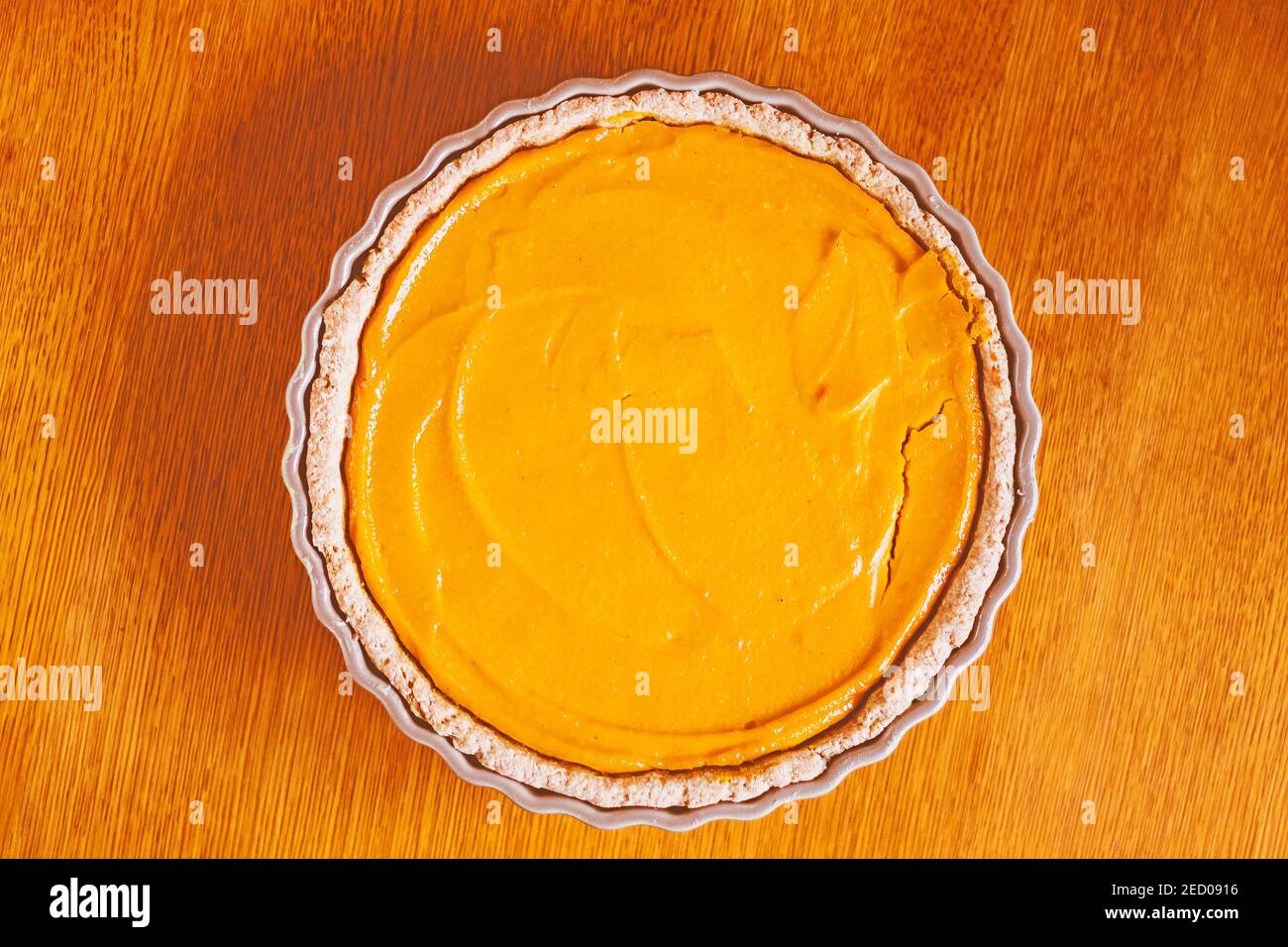 Tarte à la citrouille, gâteau à l'orange dans un plat de cuisson sur une table en bois, vue d'en haut Banque D'Images