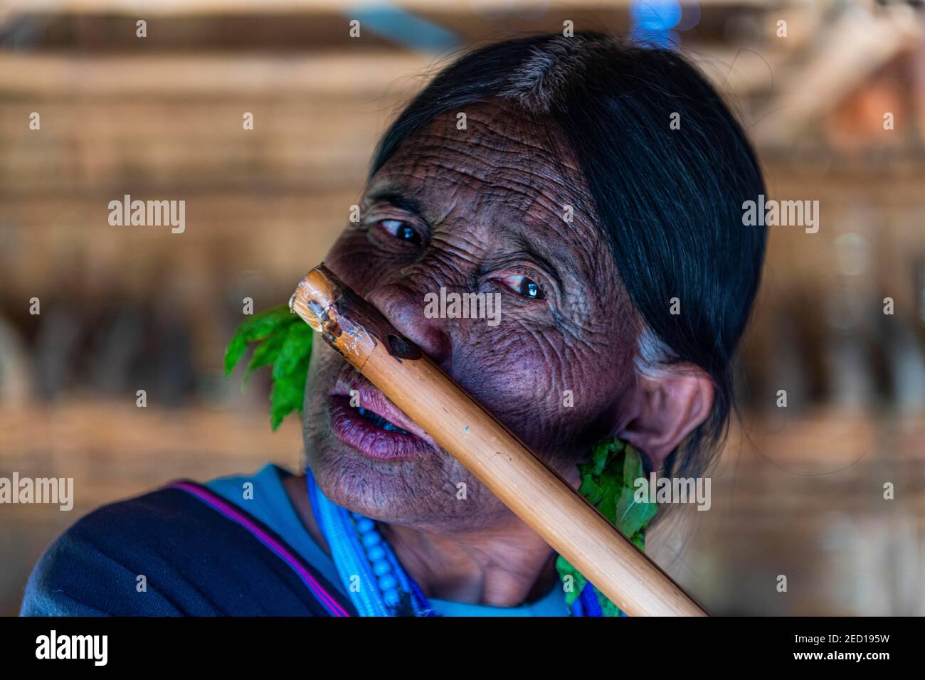 Mentonnière avec tatouage toile d'araignée soufflant une flûte avec son nez, Kanpelet, état de Chin, Myanmar Banque D'Images