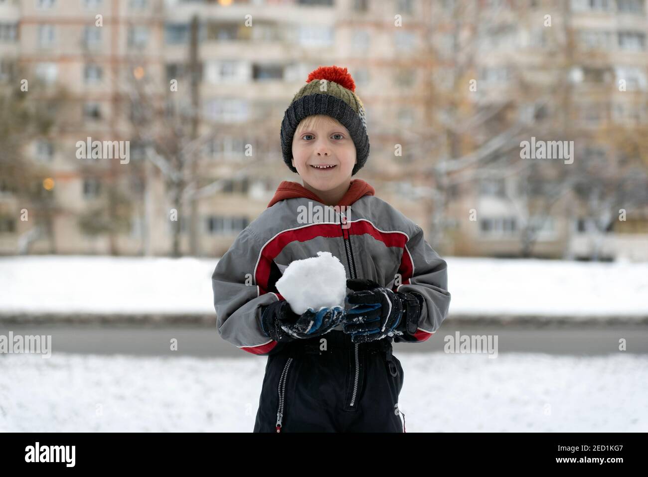 Garçon en combinaison d'hiver joue des boules de neige. Portrait de l'enfant  à l'extérieur en hiver Photo Stock - Alamy