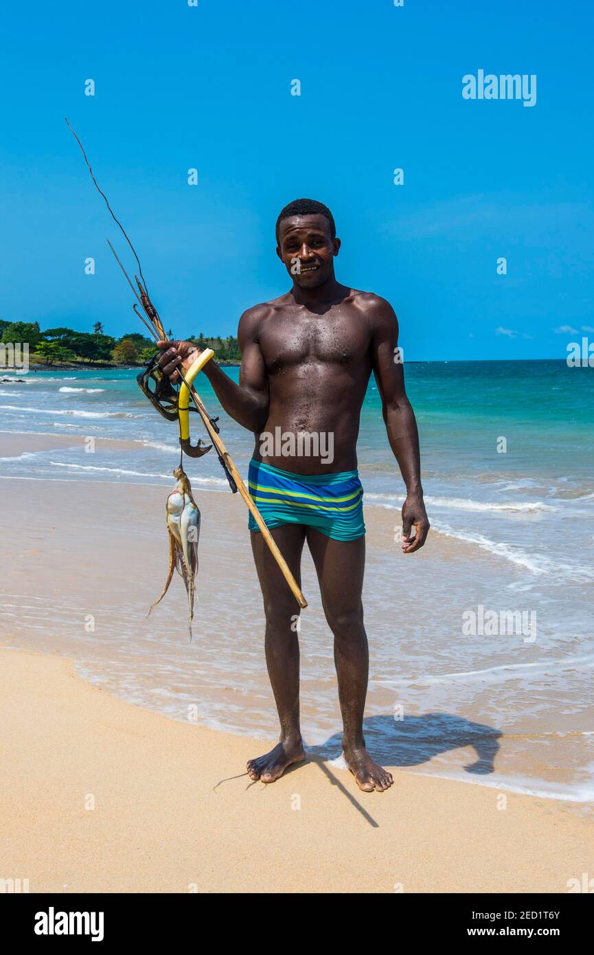 Homme avec des calamars frais pêchés sur la plage Praia dos Governadores, Sao Tomé, Sao Tomé et principe, océan Atlantique Banque D'Images