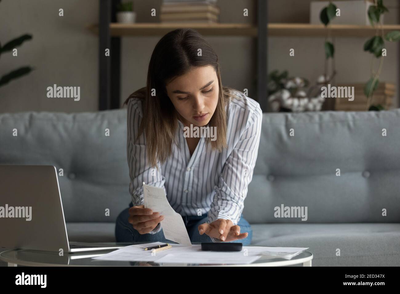 Une femme millénaire occupée s'est concentrée sur la comptabilité au bureau à domicile Banque D'Images