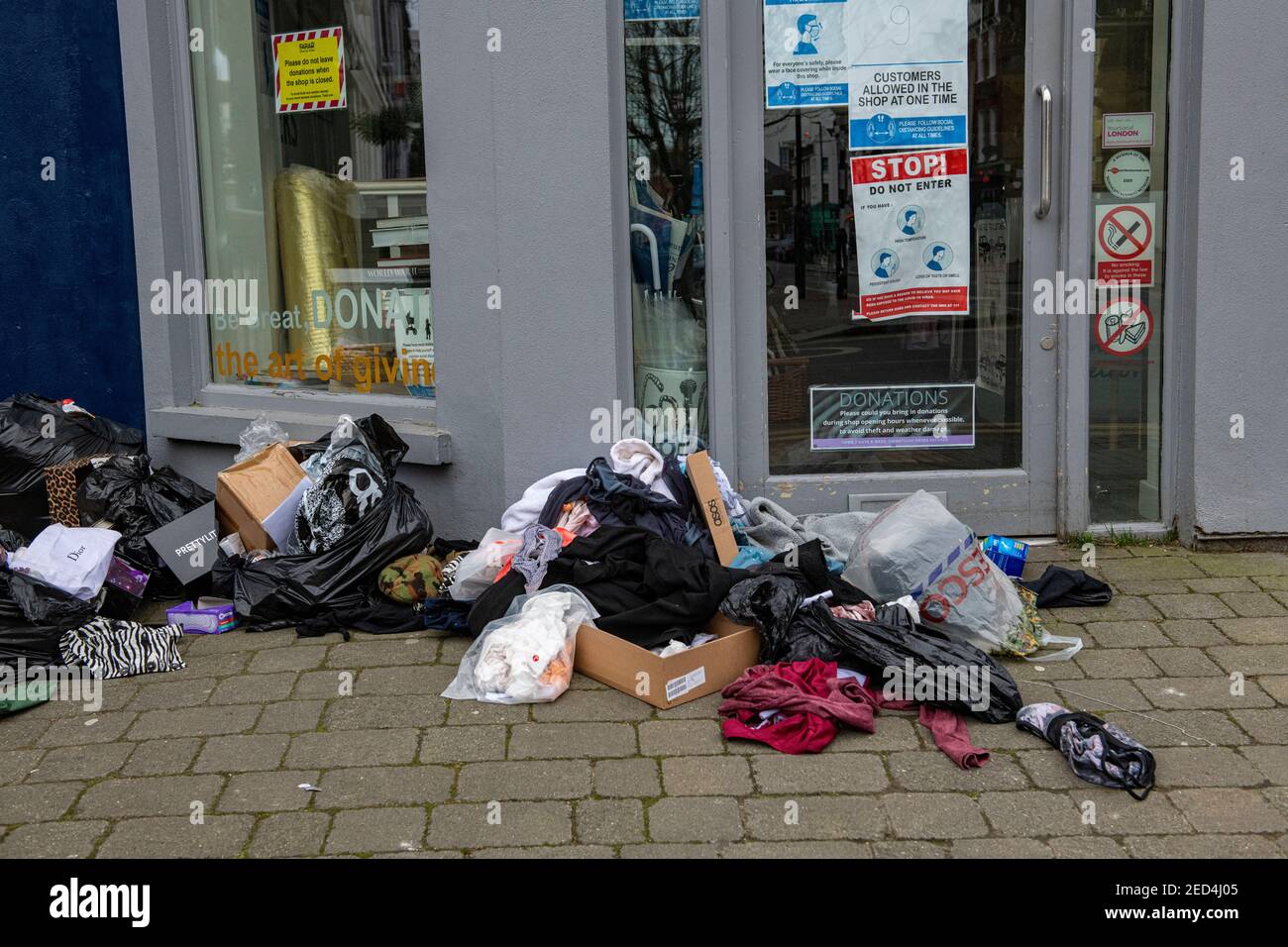 2021 sacs et sacs laissés à l'extérieur des magasins de charité fermés sont ils se sont arraché et leurs consets ont été pris Banque D'Images