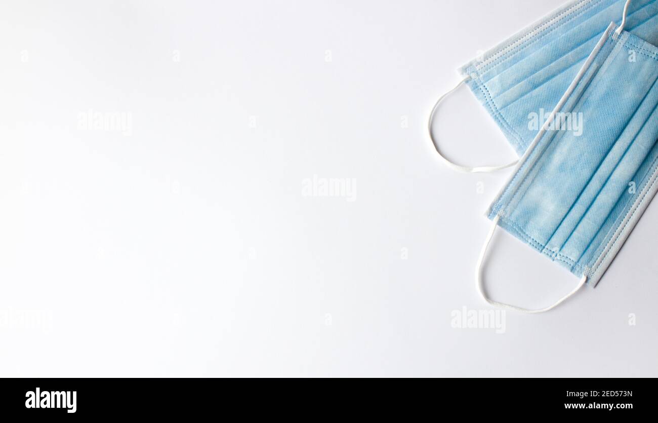 deux masques médicaux jetables bleus sur fond blanc. Minimalisme des bannières médicales. Placer pour le texte Banque D'Images