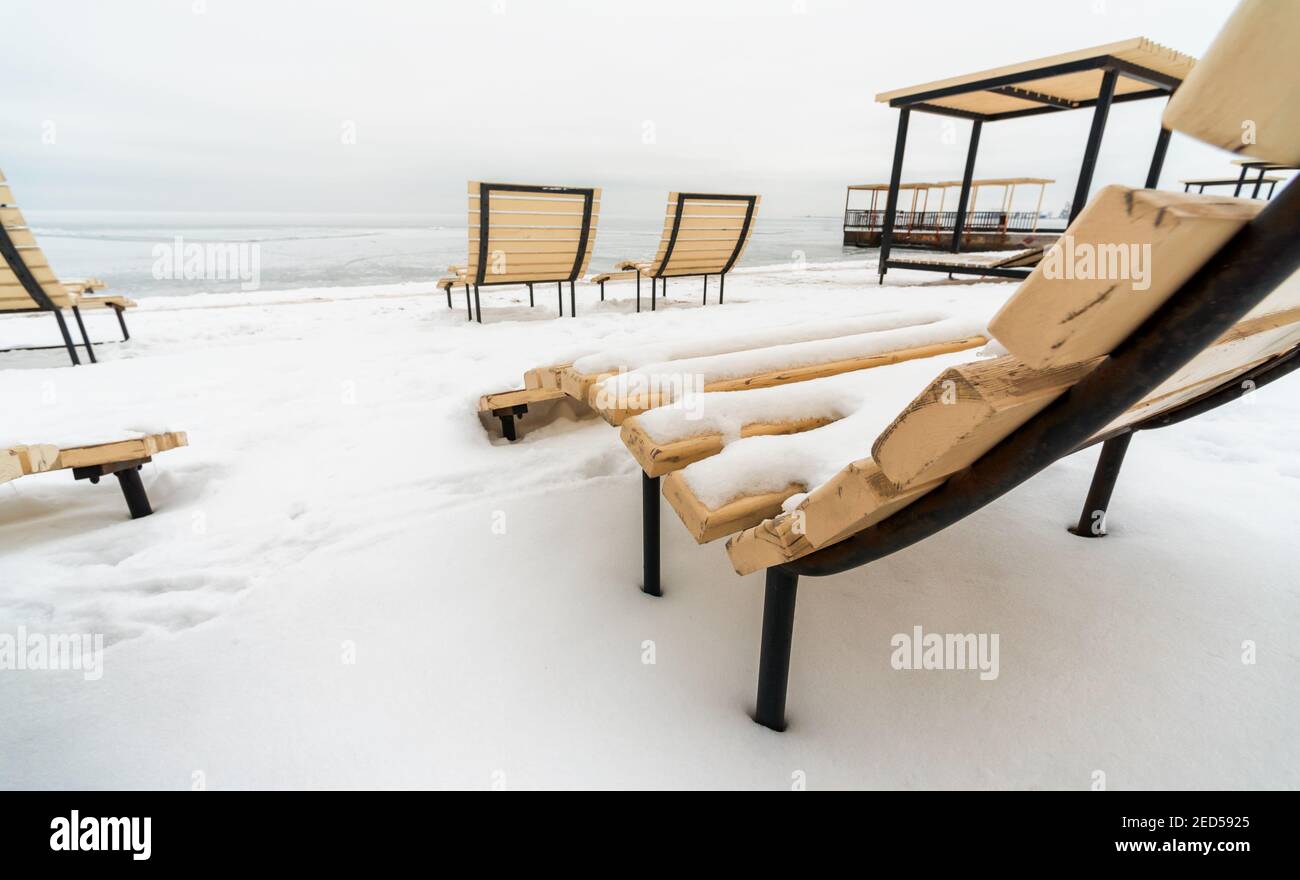 plage enneigée avec chaises longues vides en hiver sans personnes Banque D'Images
