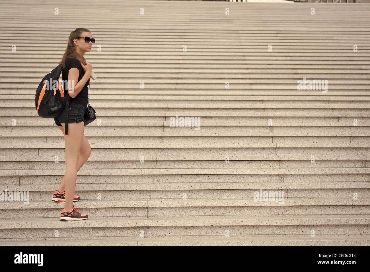 Venez voir. Escalier de tourisme de fille. Préparez-vous à explorer la ville. Femme sportive tenue noire marche. Concept de vacances et de voyage. Excursion touristique de guide touristique. Idées de vacances. Vacances dans la grande ville. Banque D'Images