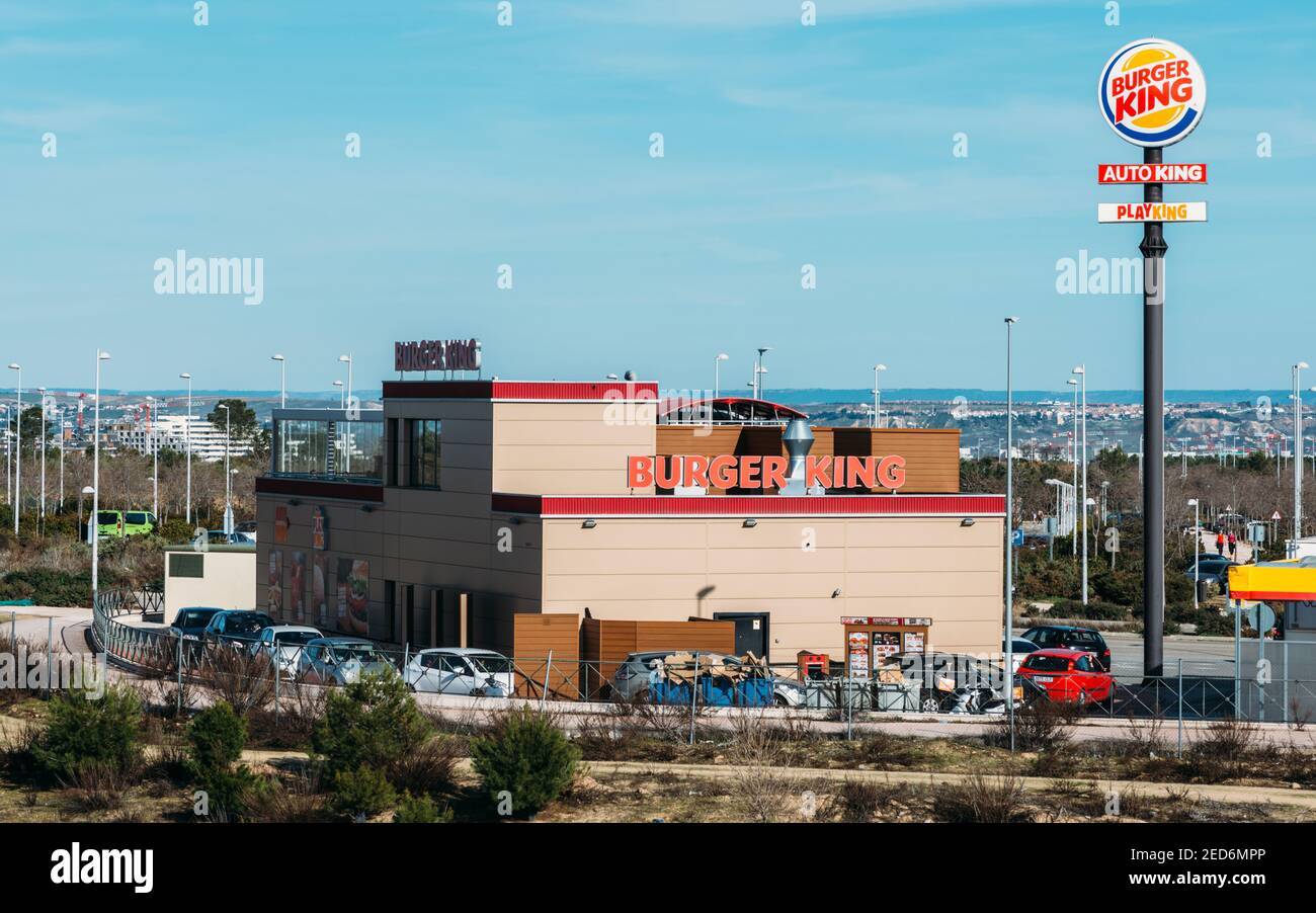 À l'extérieur, un restaurant Burger King à la restauration rapide, au look industriel futuriste et élégant, comprend un revêtement en briques et un point de commande au drive-in Banque D'Images