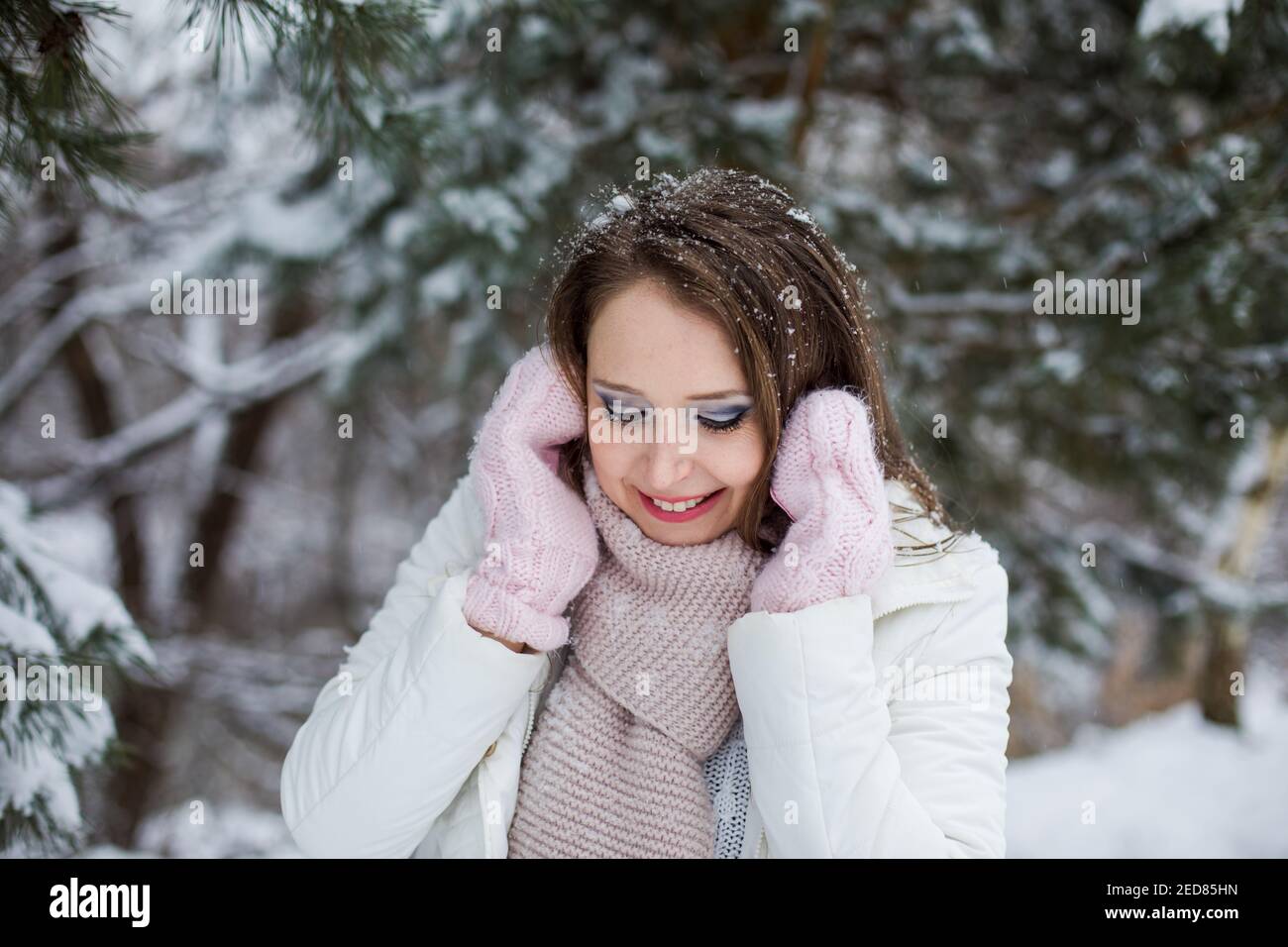 Femme regarde vers le bas et des kilomètres sous l'arbre recouvert de neige Banque D'Images