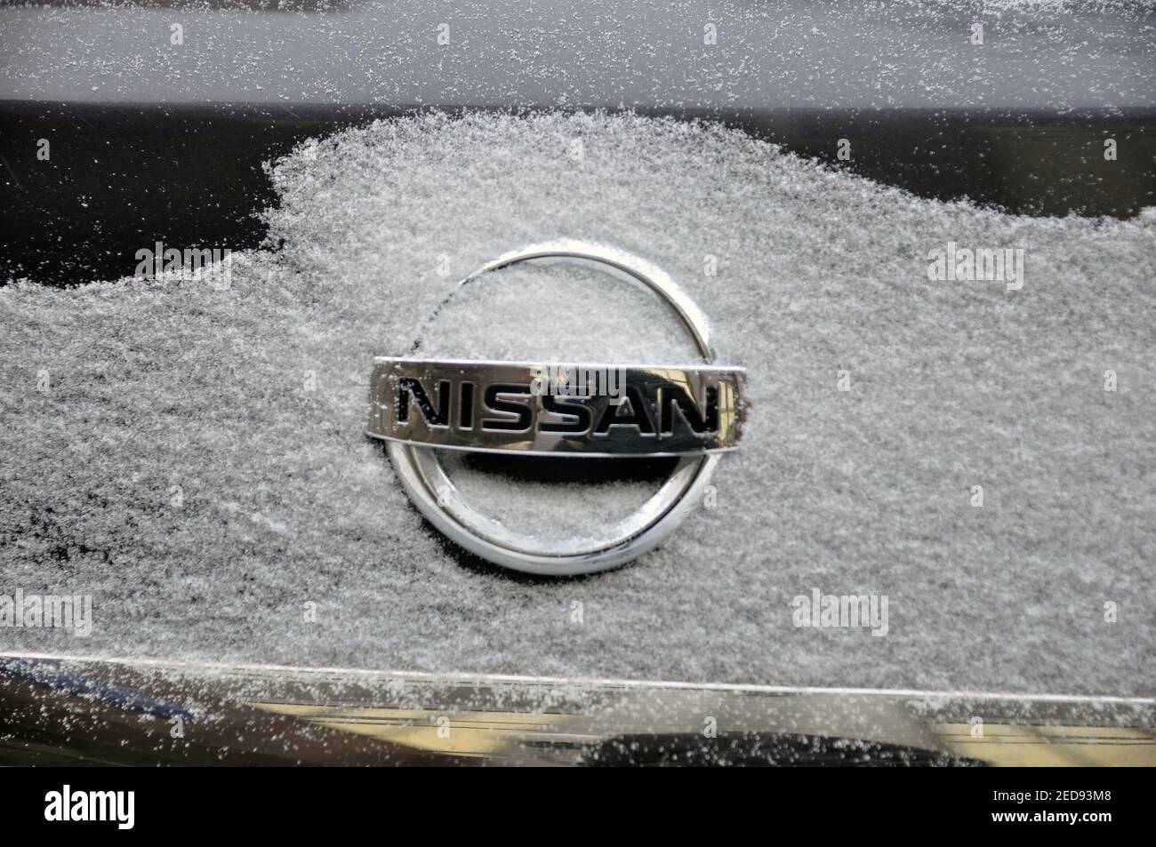 Logo de voiture Nissan sur le couvercle du coffre sous une couche de neige. Banque D'Images