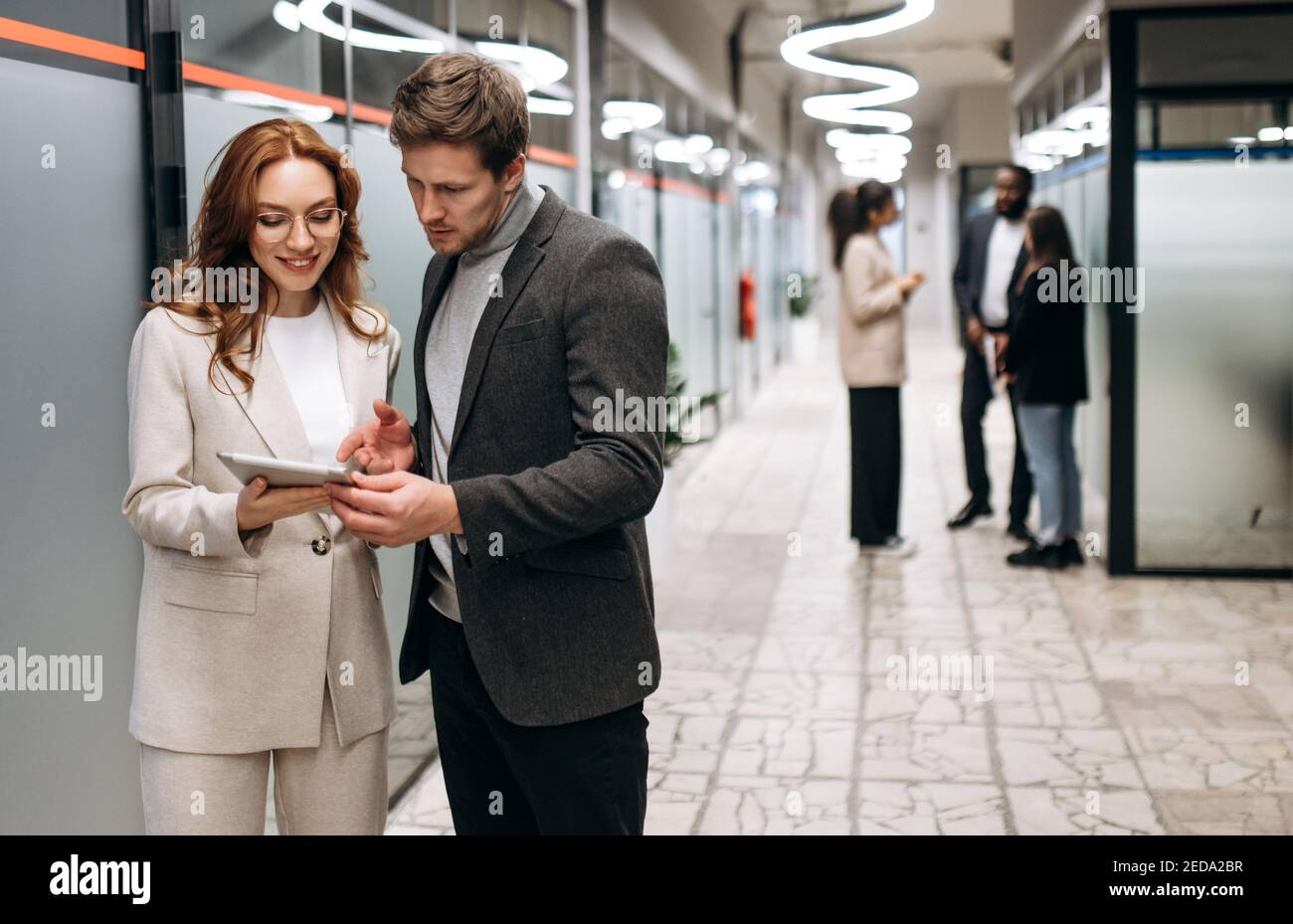 Partenaires d'affaires caucasiens sur le lieu de travail. Des collègues amicaux coopèrent pour développer ensemble une start-up ou un projet. Beau homme demander des conseils de belle femme souriante, concept de collaboration Banque D'Images