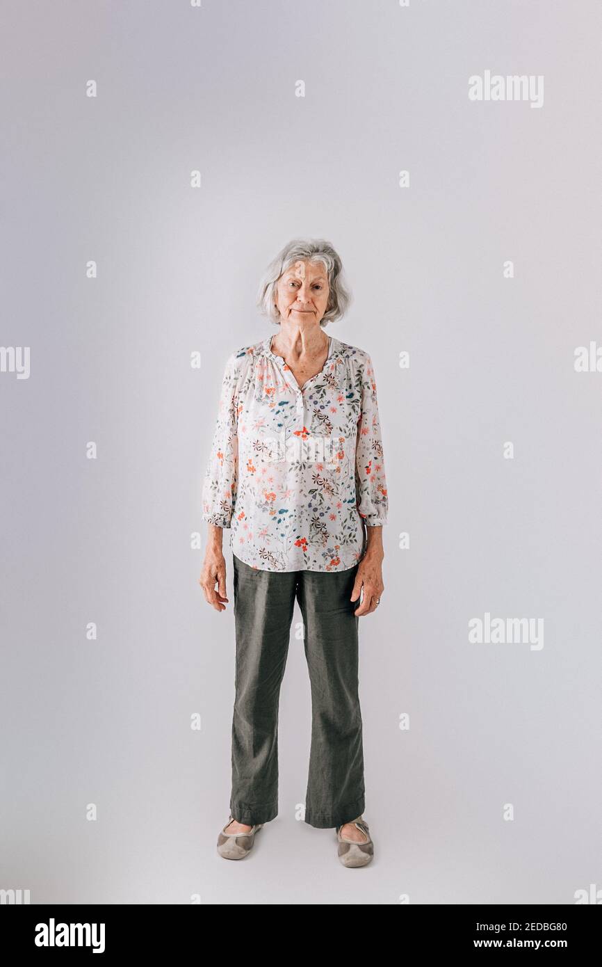 Femme âgée dans ses années 80 avec des cheveux gris debout isolés sur fond blanc Banque D'Images