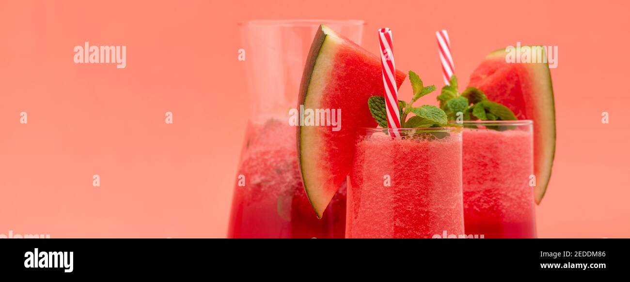 Le jus de fruits frais de pastèque lisse les boissons dans les verres sur fond de bannière rose corail avec espace de copie Banque D'Images