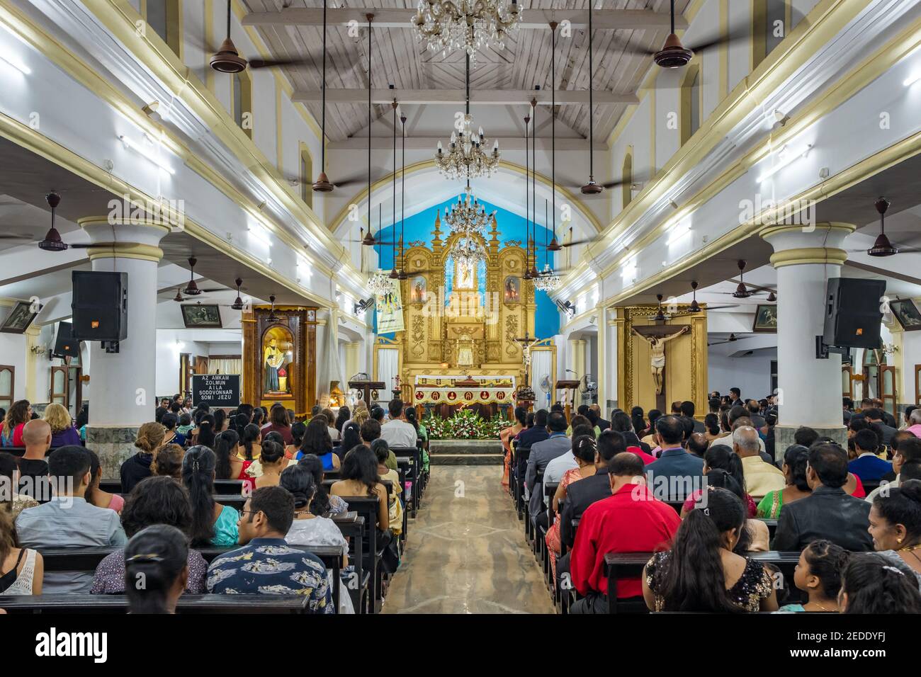 Des Indiens non identifiés priant pendant la messe de la veille de Noël dans l'église chrétienne de Goa, en Inde Banque D'Images