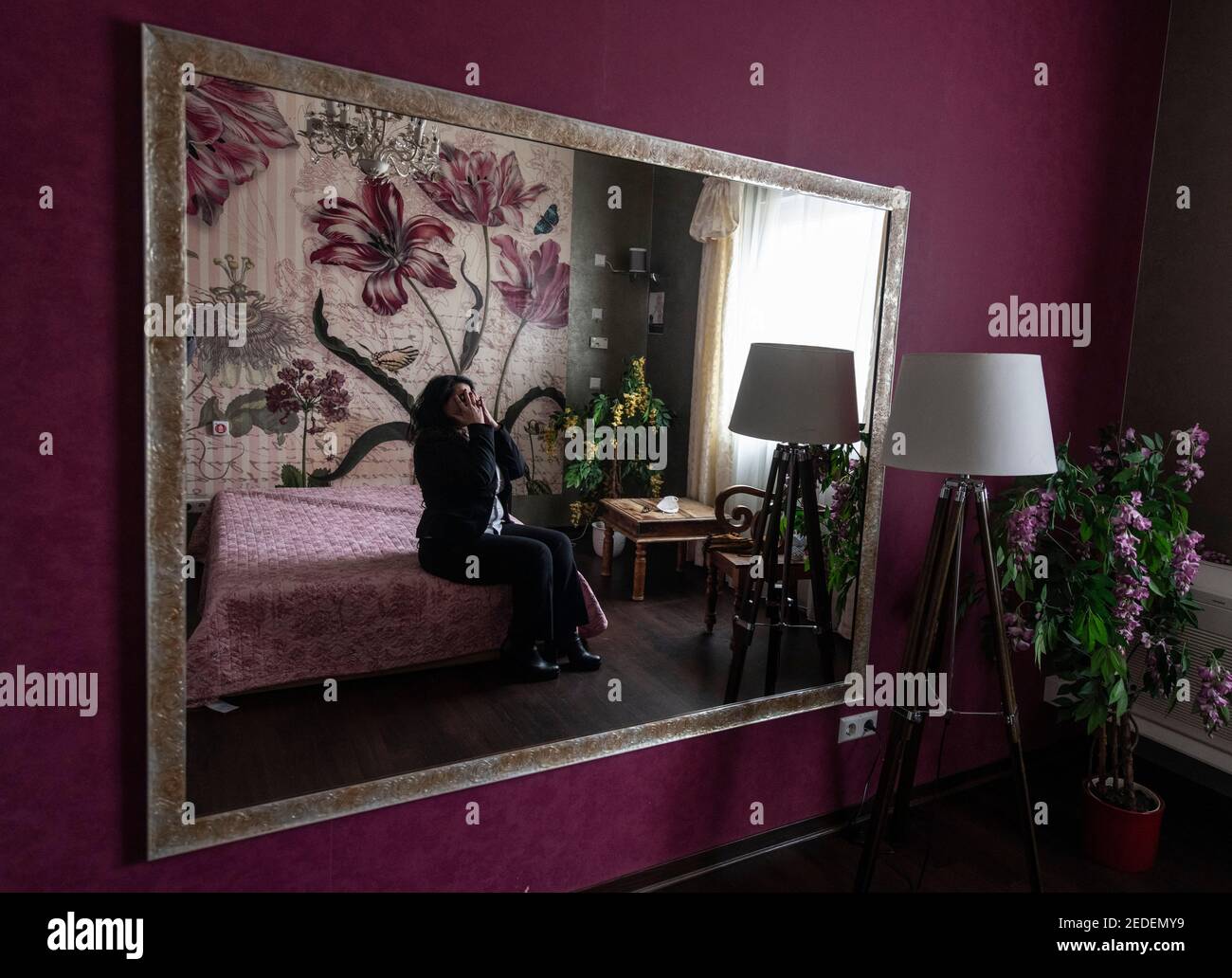 Speyer, Allemagne. 18 janvier 2021. 'Lilith' est assise sur un lit dans la maison 'Laura's Girls' de Speyer et fixe ses cheveux. Là où la prostituée attend habituellement les clients, il y a un vide béant dans le verrouillage de Corona. Il n'est pas encore clair quand les maisons de course et les maisons closes seront autorisés à rouvrir. (À dpa 'Red Light industrie souffre également de l'enfermement' de 15.02.2021') Credit: Boris Roessler/dpa/Alamy Live News Banque D'Images