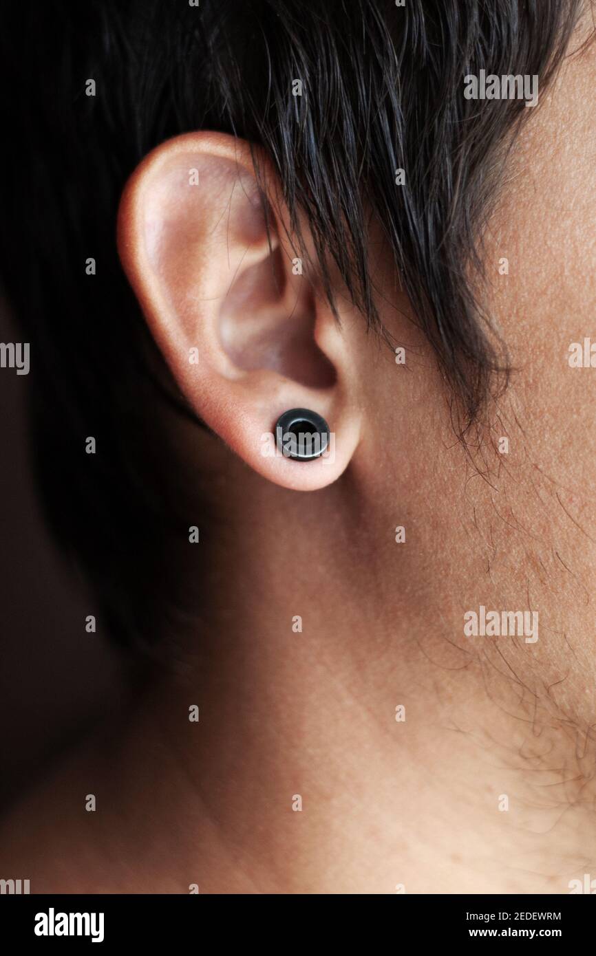 perçage d'oreilles, un gars avec un tunnel noir dans son oreille Photo  Stock - Alamy