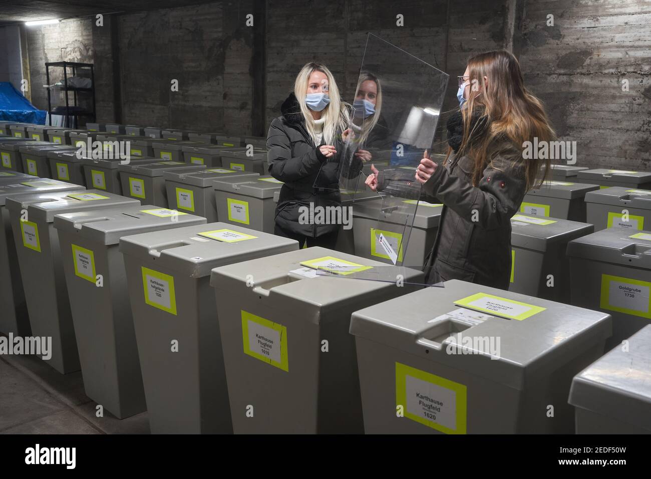 Koblenz, Allemagne. 12 février 2021. Deux employés de l'administration de la ville montent un bouclier de crache, comme il sera dans les bureaux de vote pendant l'élection de l'État. Pour chaque circonscription électorale, les municipalités reçoivent 300 euros pour des mesures d'hygiène. (À dpa '300 Euro pour Corona effort pour chaque district de vote') Credit: Thomas Frey/dpa/Alay Live News Banque D'Images