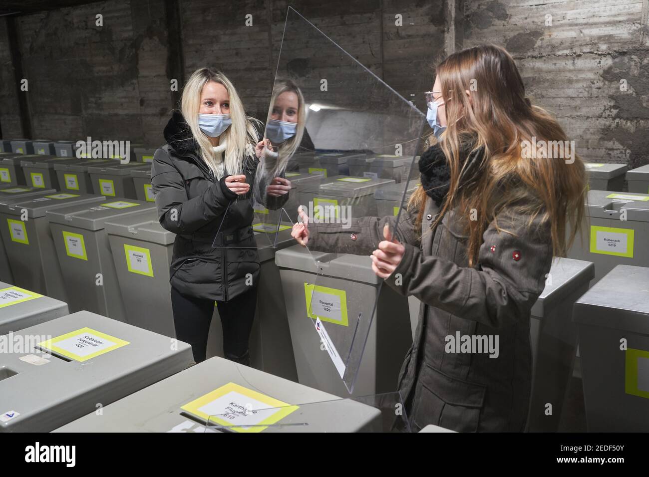 Koblenz, Allemagne. 12 février 2021. Deux employés de l'administration de la ville montent un bouclier de crache, comme il sera dans les bureaux de vote pendant l'élection de l'État. Pour chaque circonscription électorale, les municipalités reçoivent 300 euros pour des mesures d'hygiène. (À dpa '300 Euro pour Corona effort pour chaque district de vote') Credit: Thomas Frey/dpa/Alay Live News Banque D'Images