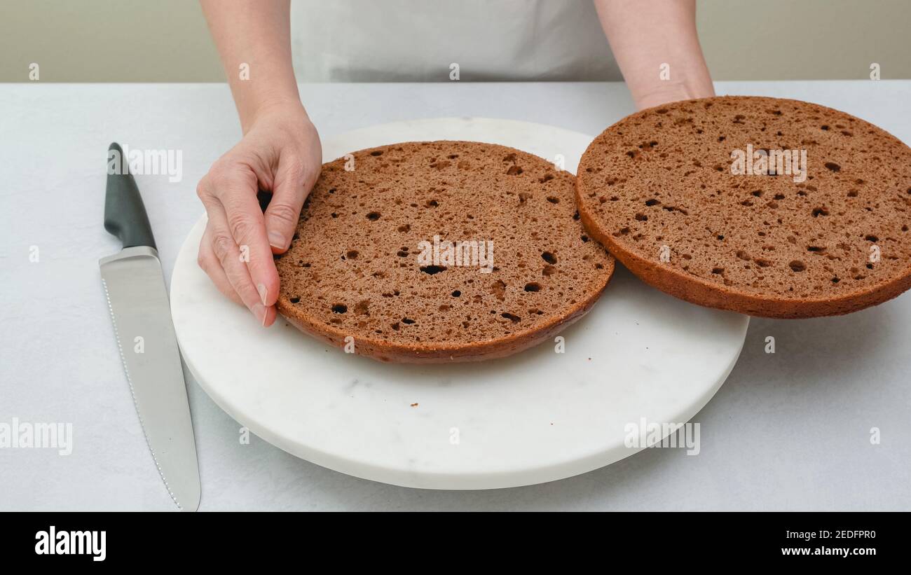 Gâteau au chocolat coupé en deux couches sur la table de cuisine. Gâteau au chocolat étape par étape avec une recette de glaçage à la crème au chocolat Banque D'Images